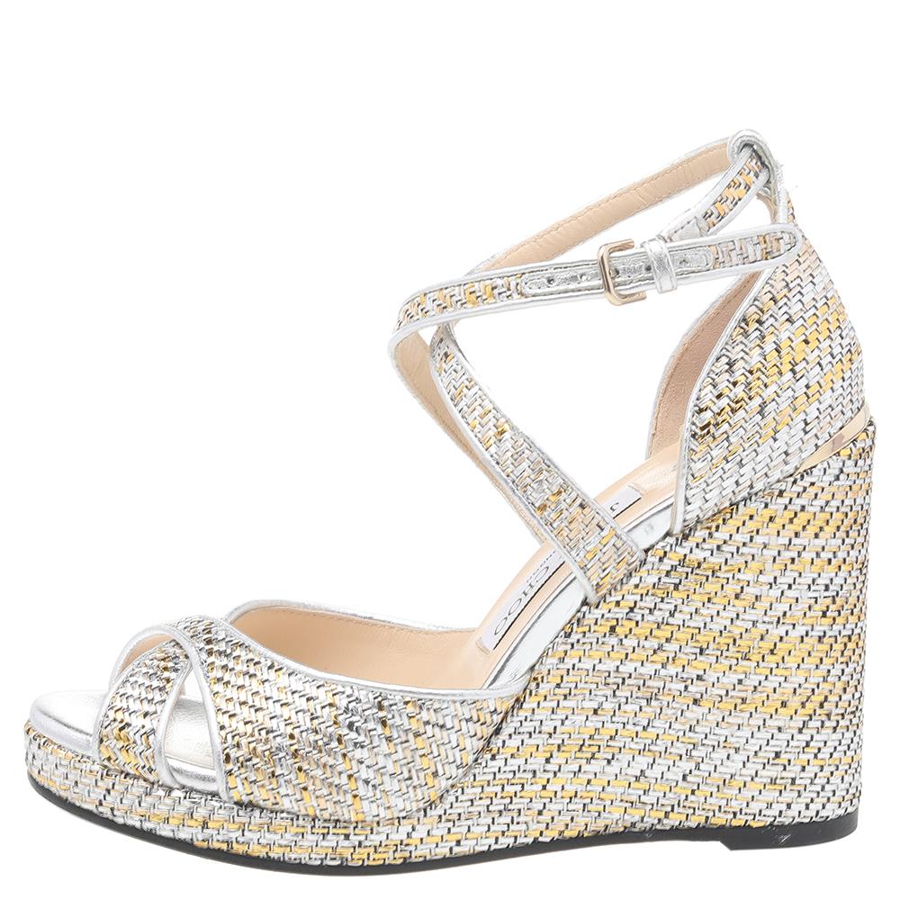 These sandals by Jimmy Choo deliver style and comfort. Crafted in Italy from woven raffia & leather trims, these multicolored sandals have a lovely silhouette. They are styled with open-toes, buckled ankle straps, platforms, 14 cm wedge heels,