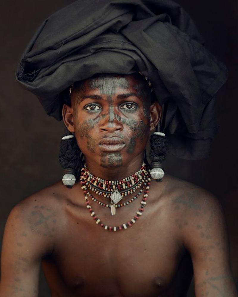 "XXVIII 6 Angelo, Soedoe Soechay,  Gerewol, Bossio, Chad, 2016

La comunidad nómada wodaabe pertenece a la etnia fulani, que se distribuye por al menos diez países norteafricanos. Chad es el hogar de muchos de los Wodaabe. Lejos de la costa y sin