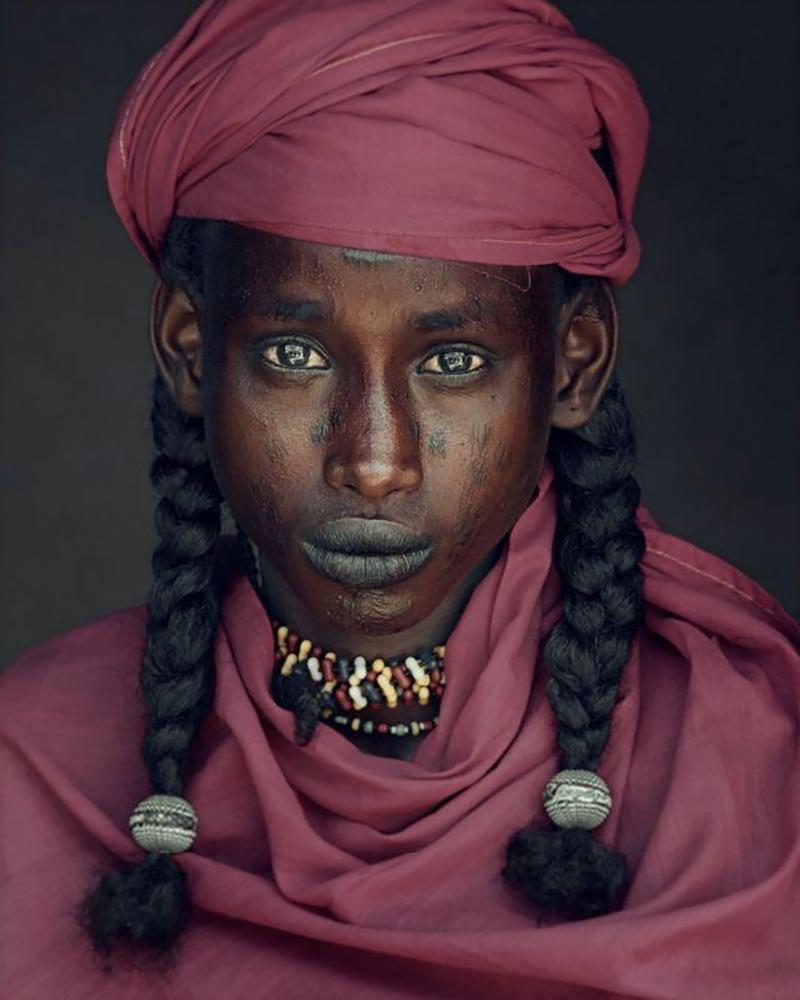 "XXVIII 6 Angelo, Soedoe Soechay,  Gerewol, Bossio, Chad, 2016

The nomadic Wodaabe community belong to the Fulani ethnic group, who are distributed across at least ten North-African countries. Chad is home to many of the Wodaabe. Far from the coast