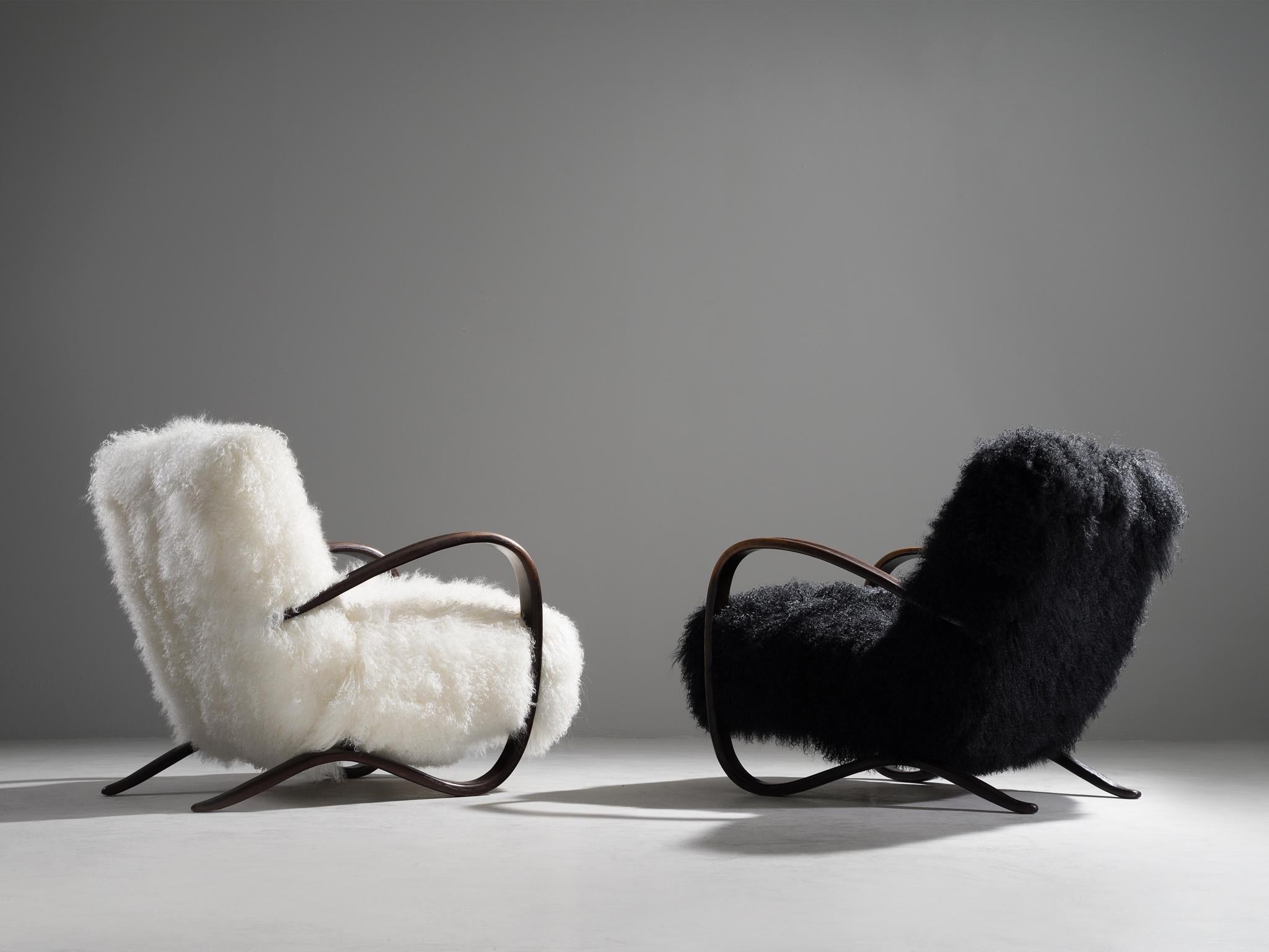 Jindřich Halabala, customizable lounge chairs, beech, Tibetan wool, Czech Republic, 1930s

Extraordinary black and white easy chairs with Tibetan lamb’s wool upholstery. These chairs have a very dynamic and abundant appearance and the fuzzy