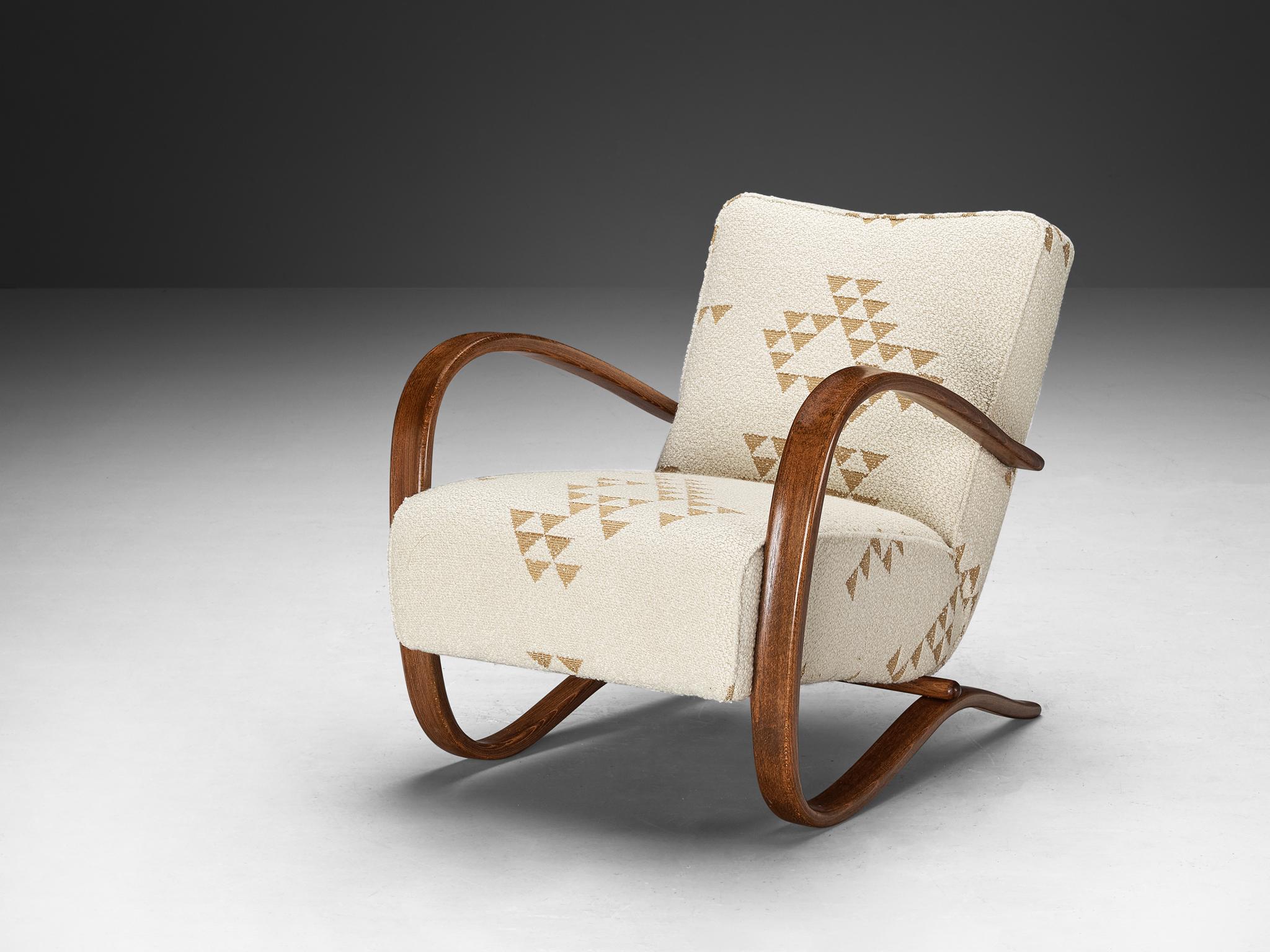 Jindrich Halabala, lounge chair, model 'H269', fabric, stained beech, Czech Republic, 1930s.

Extraordinary easy chair upholstered in a neutral fabric with geometrical shapes. This design shows a very dynamic and abundant appearance. Beautifully