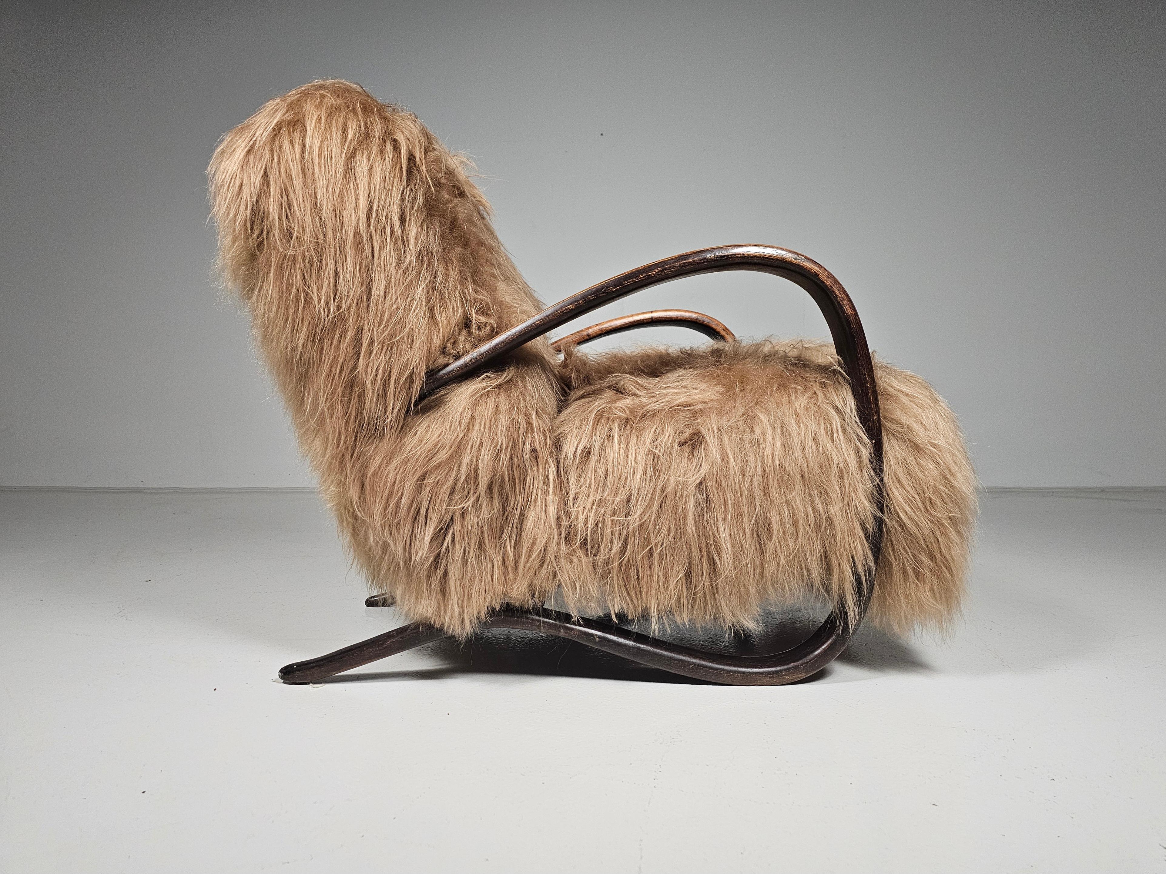 Jindrich Halabala, lounge chair, model 'H269', dark stained beech, Reupholstered in long hair mongolian sheepskin in a beige honey color. Czech Republic, 1930s.

This chair has a very organic and abundant appearance and the fuzzy upholstery gives it