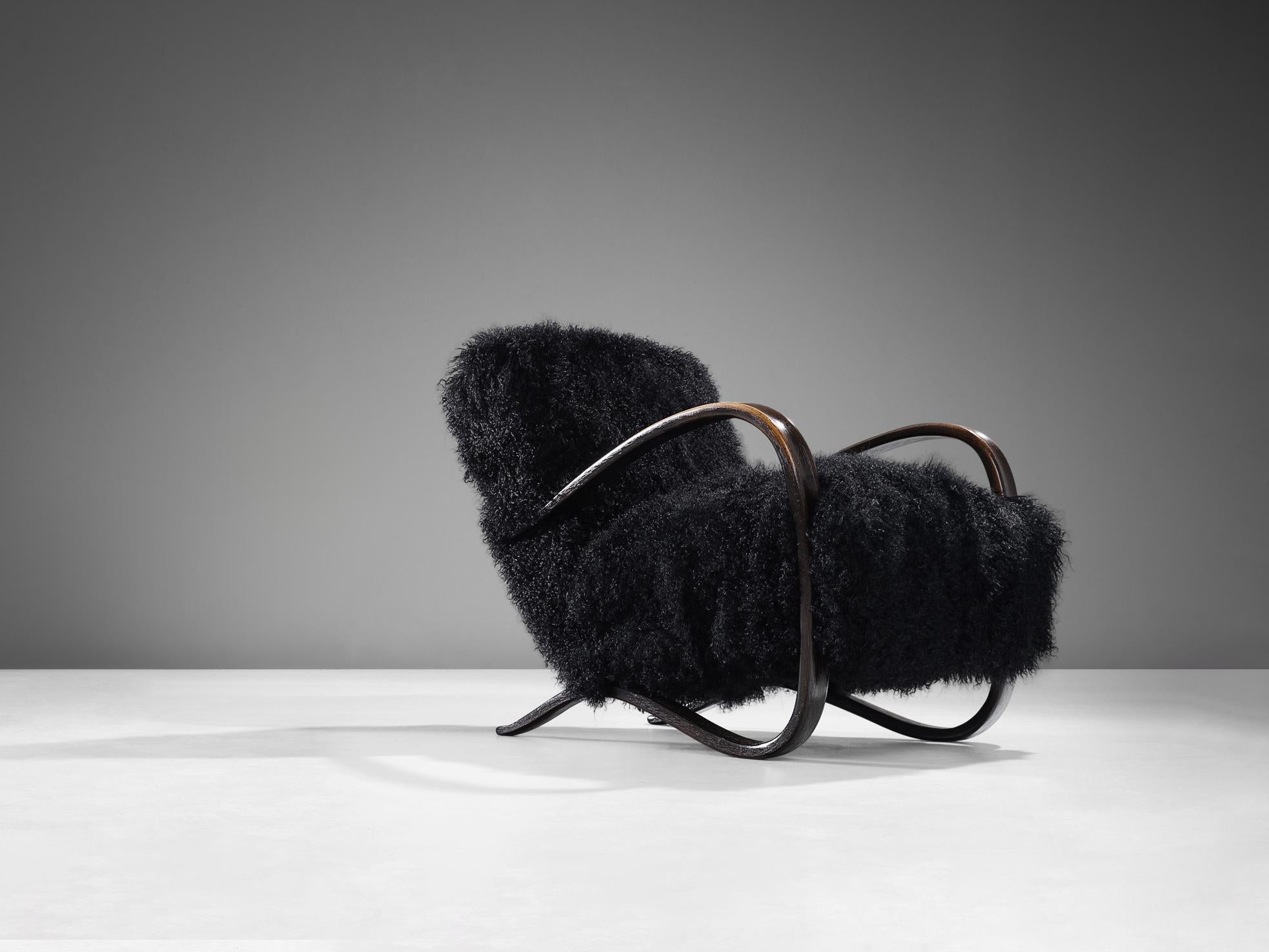 Jindrich Halabala, lounge chair, model 'H269', stained beech, Tibetan lambswool, Czech Republic, 1930s.

Extraordinary easy chair in black Tibetan lambswool upholstery. This design has a very dynamic and abundant appearance and the fuzzy upholstery