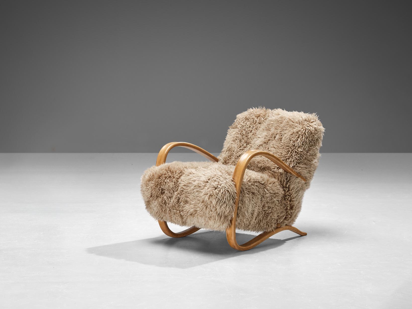 Jindrich Halabala, lounge chair, model 'H269', stained beech, Tibetan lambswool, Czech Republic, 1930s.

Extraordinary easy chair in beige brown Tibetan lambswool upholstery. This chair has a very dynamic and abundant appearance and the fuzzy