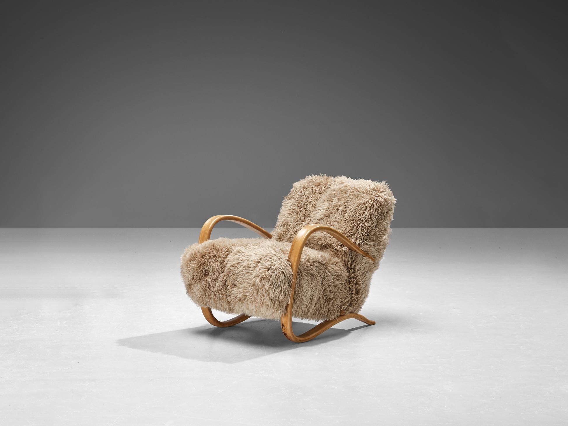 Jindrich Halabala, lounge chair, model 'H269', stained beech, reupholstered in sheepskin 