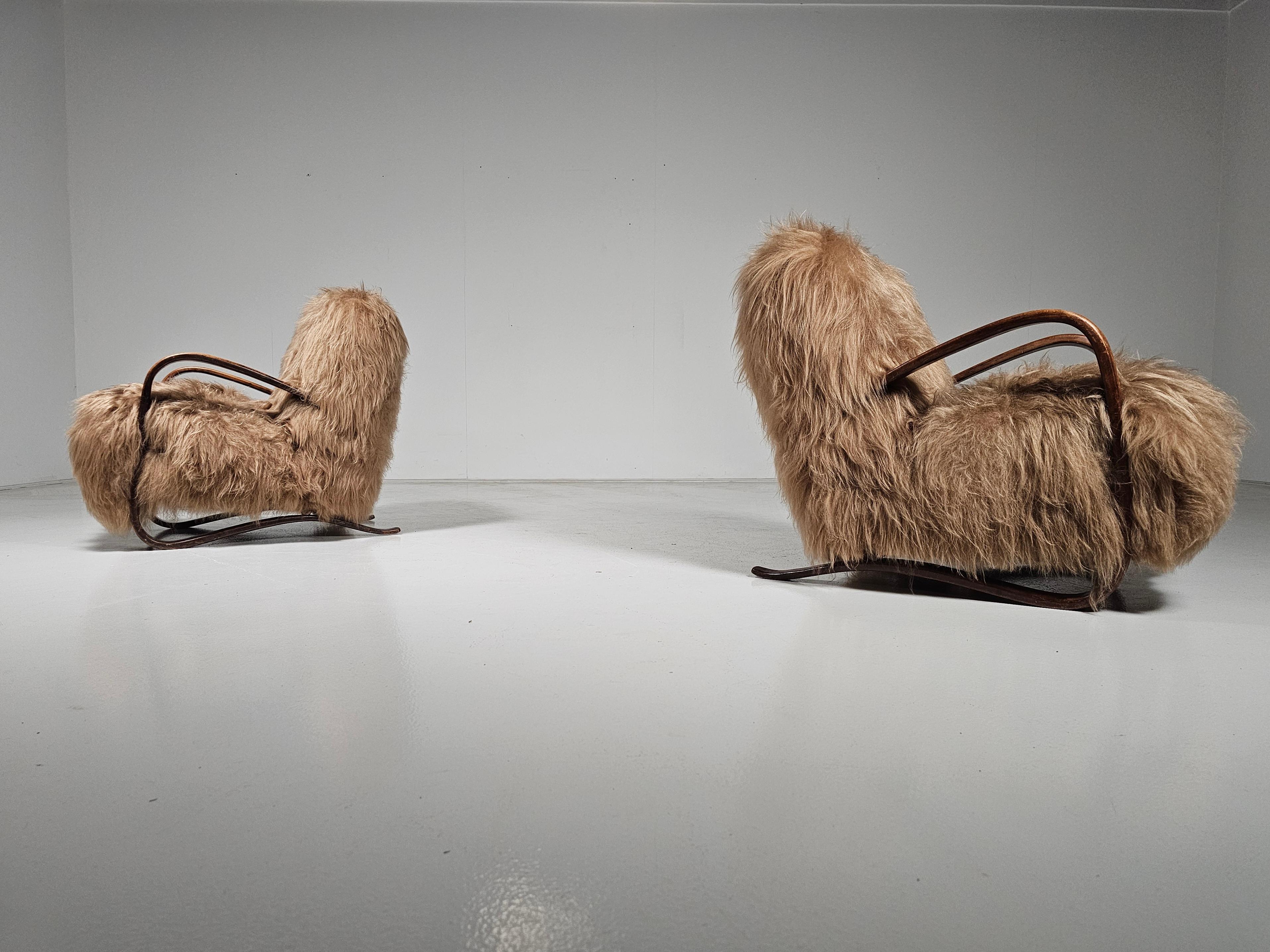 Jindrich Halabala, poltrone da salotto. modello 'H269', faggio tinto marrone chiaro, rivestite in pelle di pecora mongola a pelo lungo di colore beige miele. Repubblica Ceca, anni '30.

Le sedie hanno un aspetto molto organico e abbondante, e