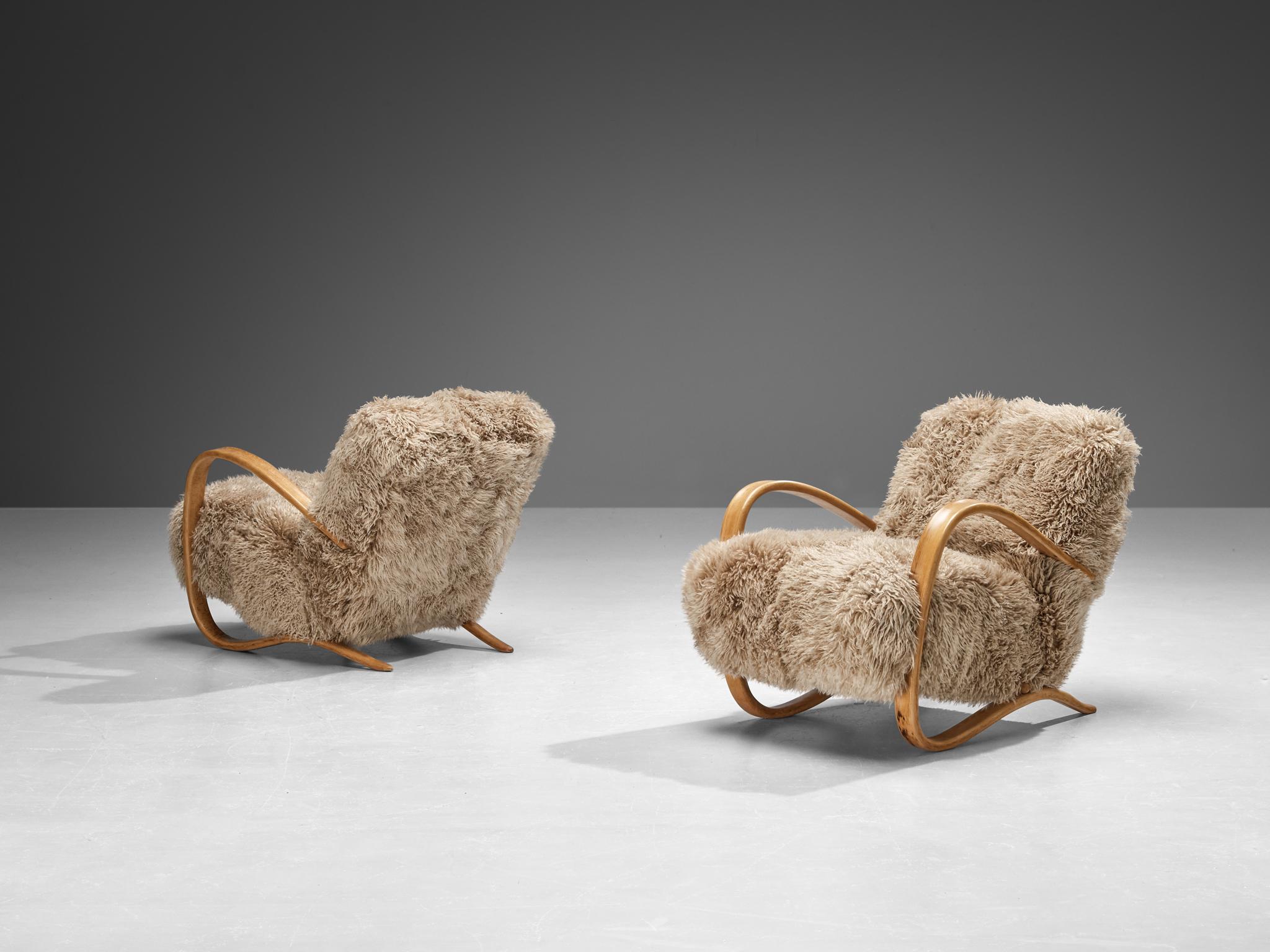 Jindrich Halabala, lounge chairs, model 'H269', stained beech, Tibetan lambswool, Czech Republic, 1930s.

Extraordinary easy chairs in brown Tibetan lambswool upholstery. These chairs have a very dynamic and abundant appearance and the fuzzy