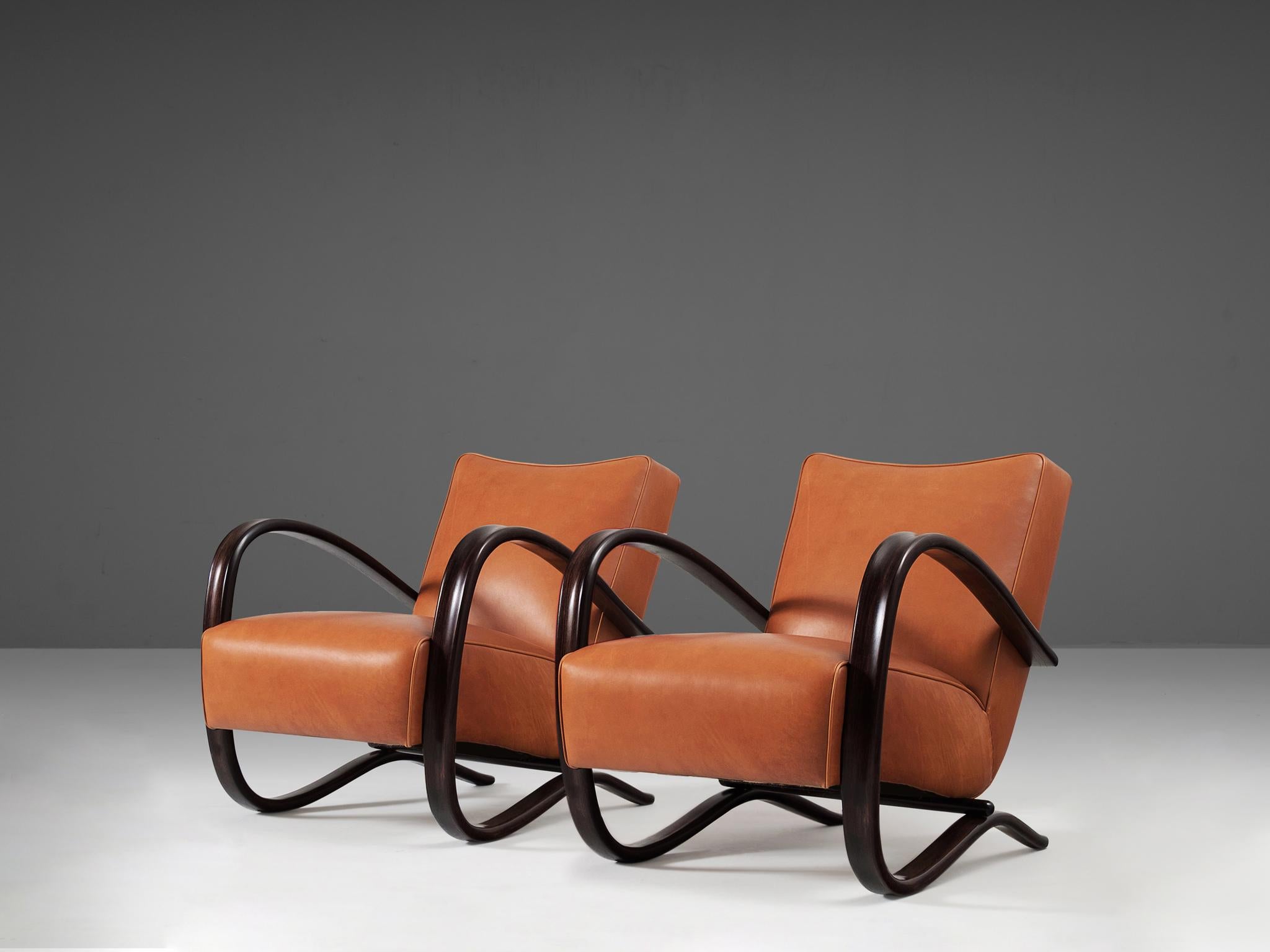 Jindrich Halabala, lounge chairs, model 'H269', stained beech, leather, Czech Republic, 1930s.

Extraordinary easy chairs upholstered in a fine cognac brown leather. These armchairs have a very dynamic and abundant appearance and the leather gives