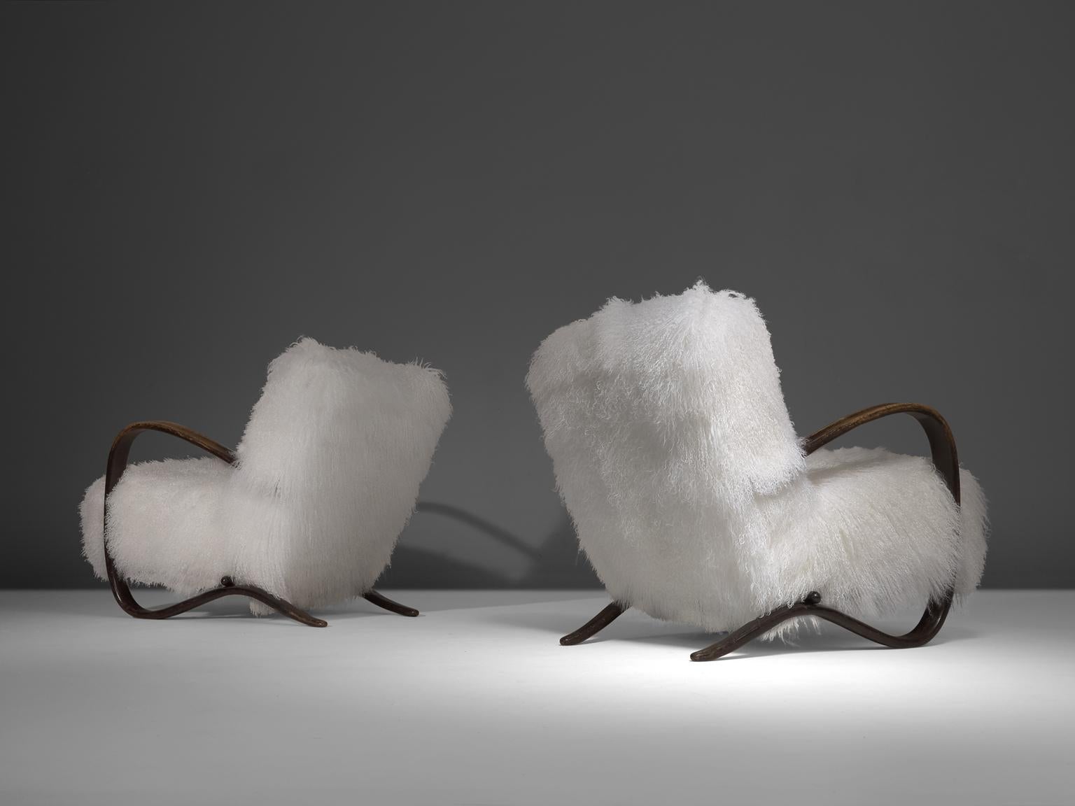 Pair of lounge chairs, in stained beech and sheepskin, by Jindrich Halabala (1903-1978), Czech Republic, 1930s. 

Extra ordinary pair of white easy chairs with Tibetan lambswool upholstery. These chairs have a very dynamic and abundant appearance.