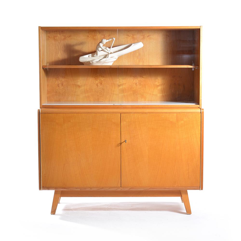 Simple and beautiful sideboard produced by Jitona furniture company in Czechoslovakia in the 1960s. The top part has a glass showcase with sliding doors and a white opaline glass on the bottom, which is a beautiful little detail. The bottom part