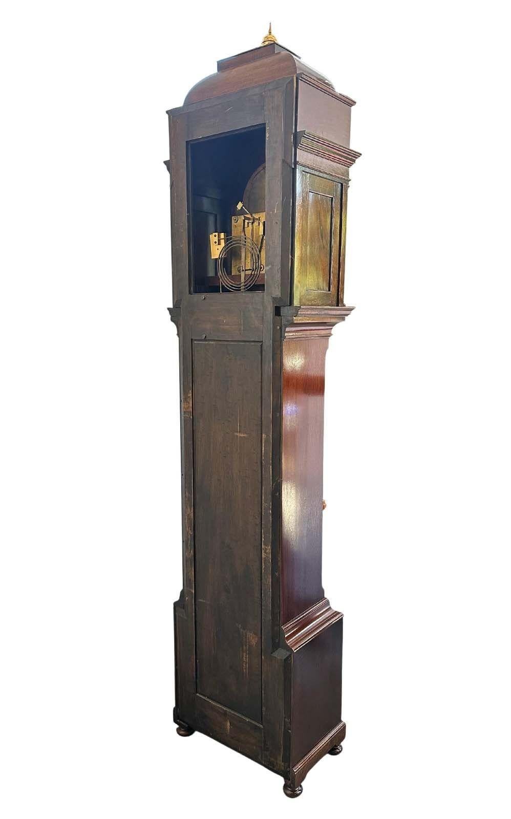 Impressive English mahogany clock by J.J. Elliot retailed by Tiffany & Co. showcasing delicate floral marquetry. The sculptural bonnet adorned with brass spire finials embellish the artistry of this beautiful antique mirror.
Includes brass and