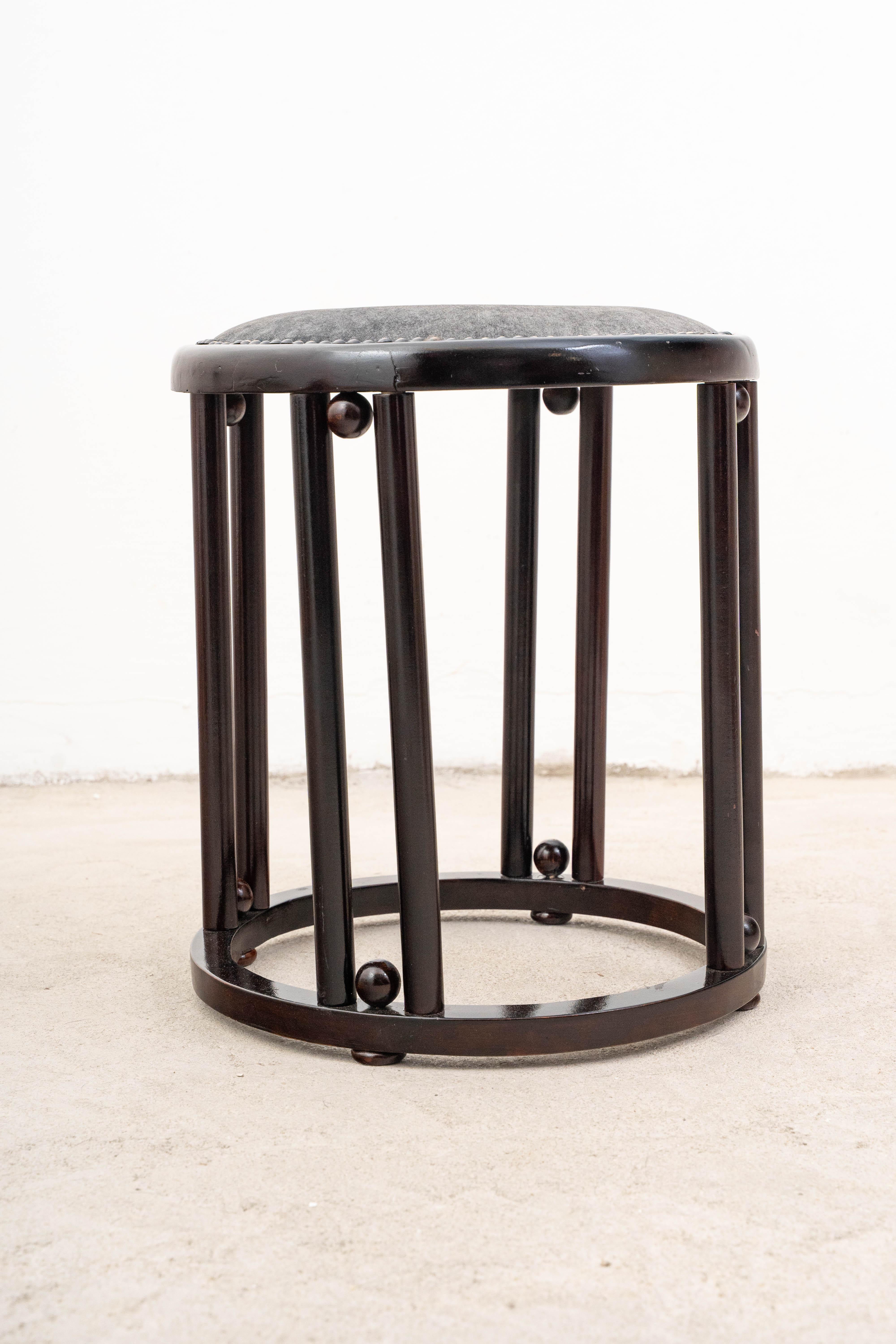 Fabricado hacia 1900 por la renombrada J.&J. Kohn, este llamativo taburete, diseñado por el visionario Josef Hoffmann, se erige como un parangón del diseño modernista temprano del movimiento secesionista vienés. Tallada en madera de haya oscura y