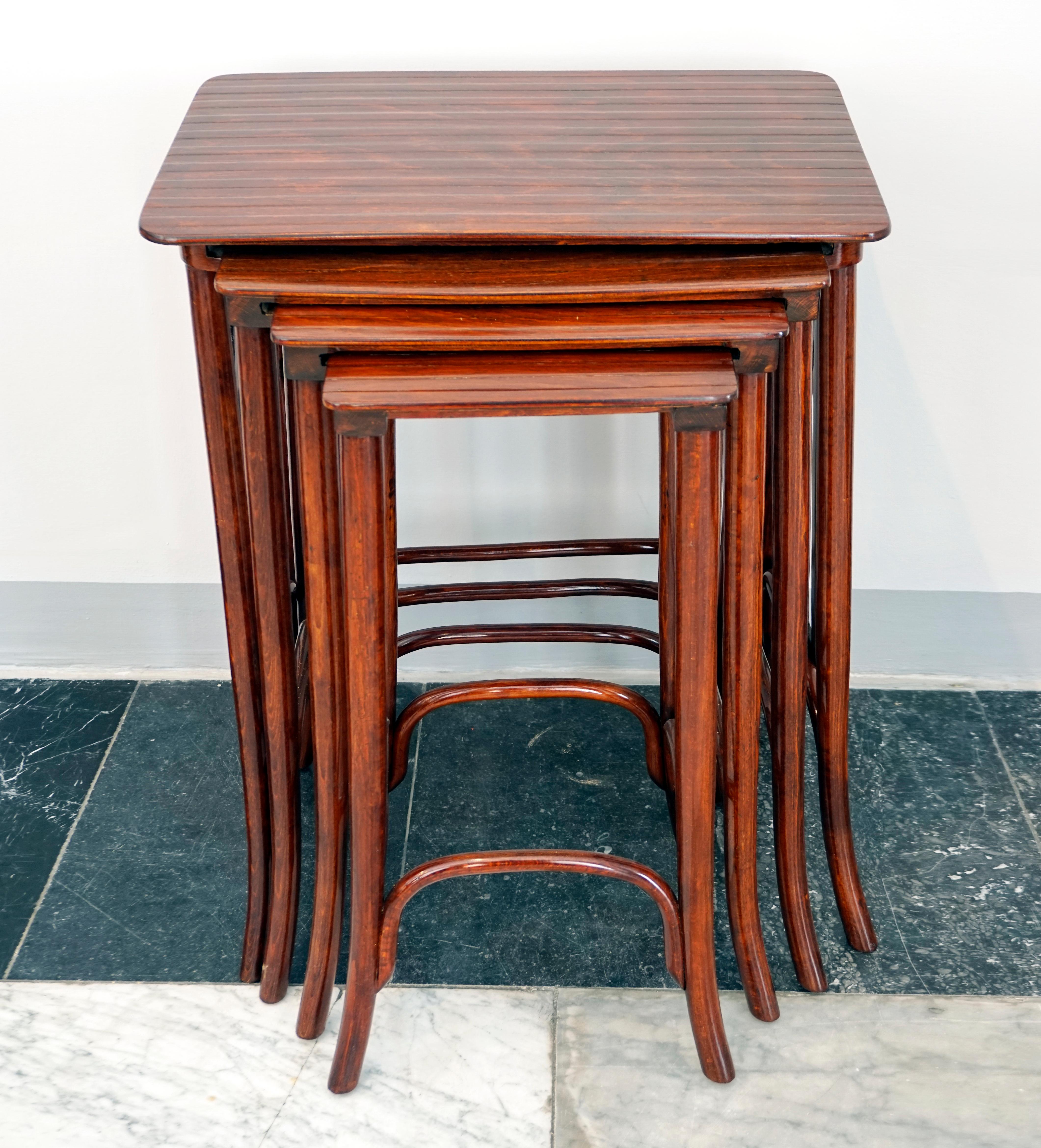 High-quality handcrafted placemat, shapely beech bentwood, stained mahogany, shellac hand-polished: Four nesting side tables in different sizes with an elegant design, table tops with a structured surface, side elements with a stylized flower.
