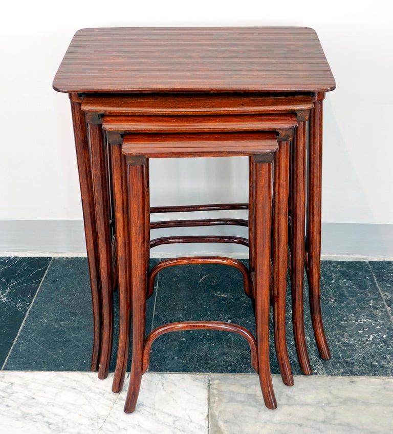 High-quality handcrafted placemat, shapely beech bentwood, stained mahogany, shellac hand-polished: Four nesting side tables in different sizes with an elegant design, table tops with a structured surface, side elements with a stylized flower.
