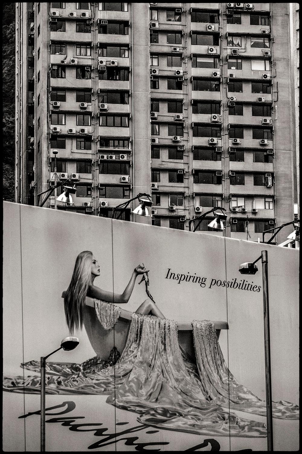 Inspiring possibilities
Edition of 25
signed and numbered by the artist

The text could not have been better placed in front of the block of flats in hong kong. Luxury advertising in front of a house in a poor neighbourhood.

JJK is a pseudonym for
