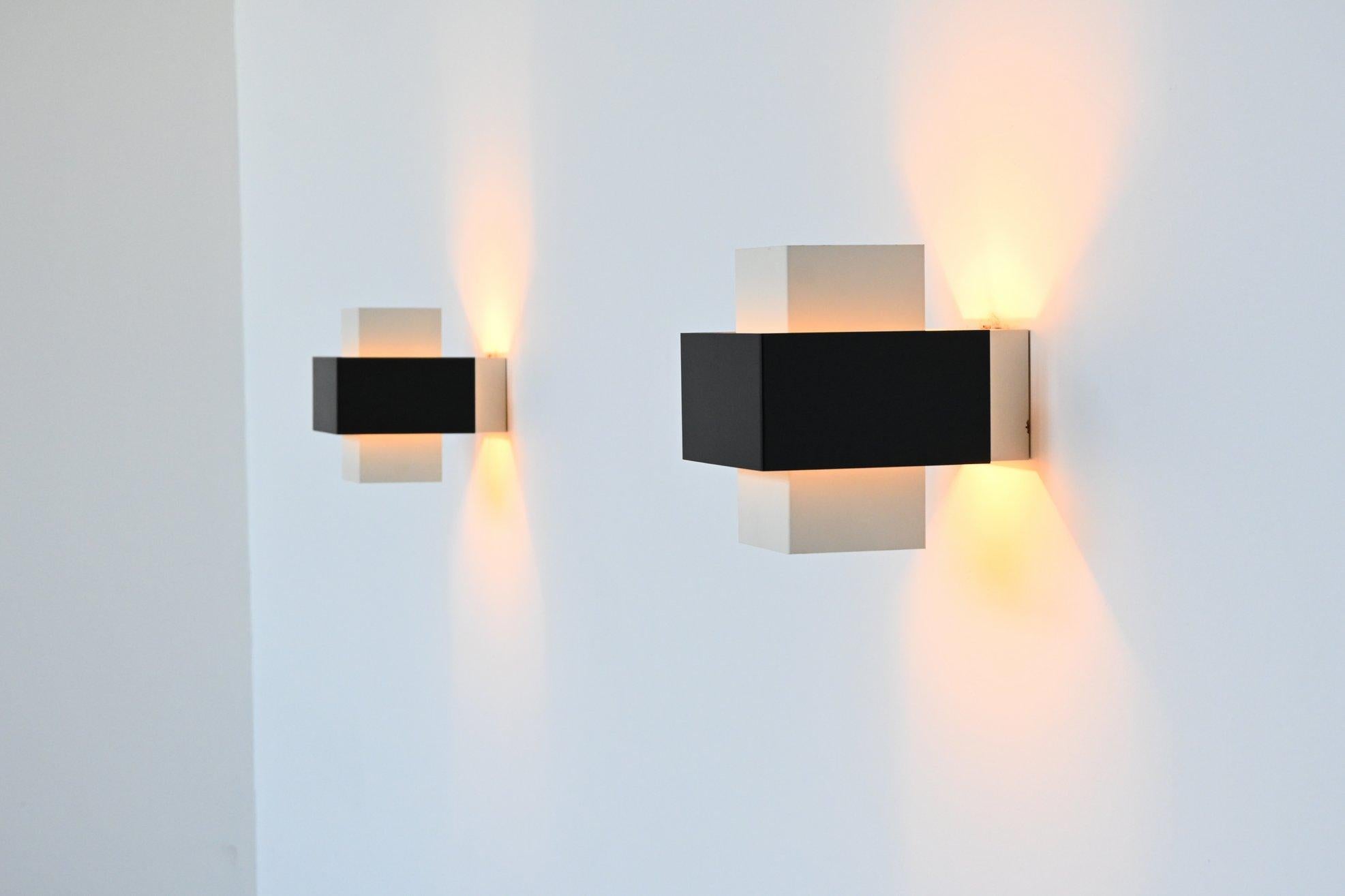 Very nice cubistic pair of sconces designed by Johannes Joseph Maria Hoogervorst for Anvia, the Netherlands, 1960. These wall lamps are made of black and white lacquered metal, beautiful in contrast to each other. The light spreads up and down which