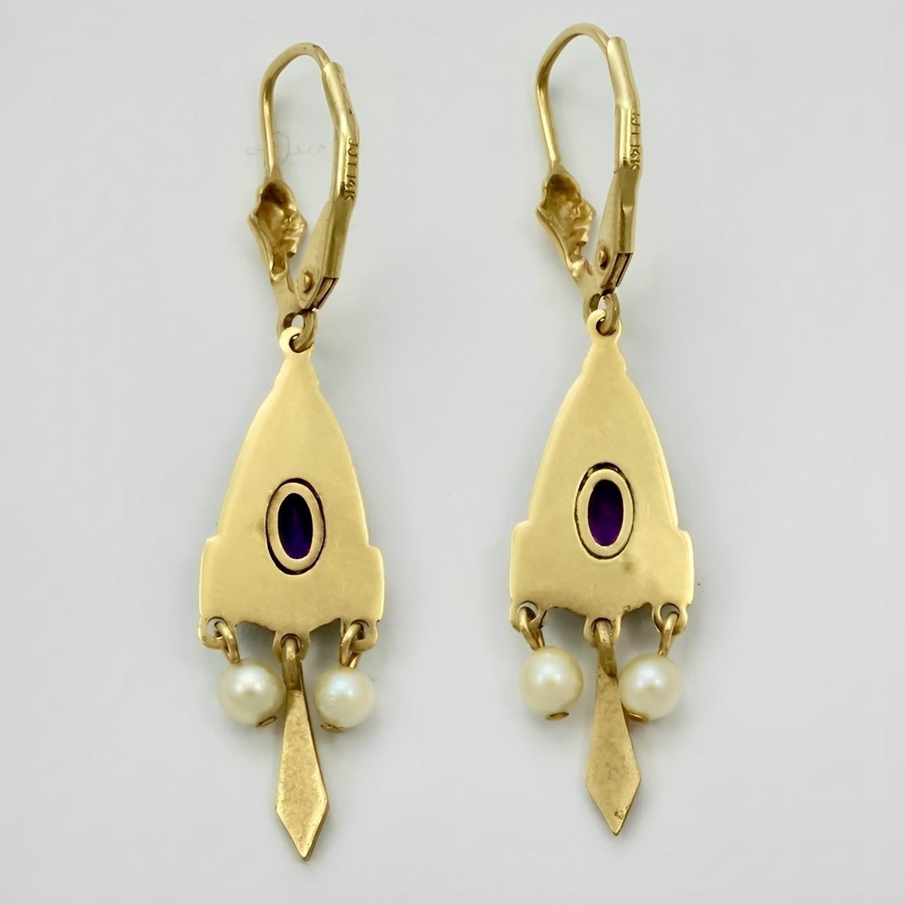 Beautiful 14K gold earrings with cultured pearls and purple stones. The ornate design is highlighted in black enamel. Length including the leverbacks 4.1 cm / 1.6 inches.

This is a lovely pair of Victorian style gold earrings with movement..
