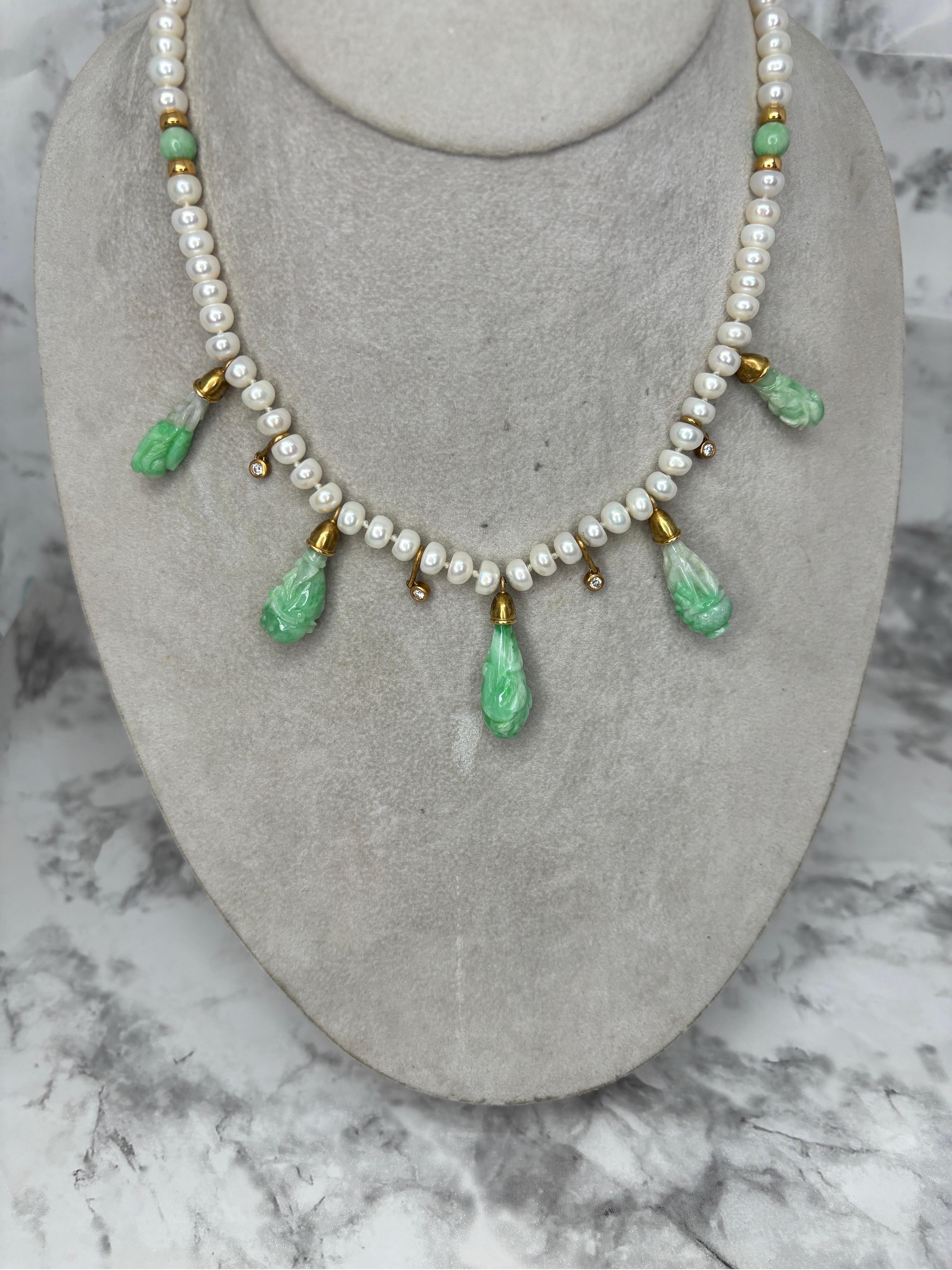 Diese exquisite Halskette aus geschnitztem Jadeit, Diamanten und Perlen aus 18 Karat Gelbgold ist ein Meisterwerk der Juwelierkunst, das Eleganz, Handwerkskunst und die zeitlose Anziehungskraft kostbarer Materialien vereint. 

Die Halskette besteht