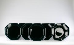 I.L.A. Ensemble de douze assiettes noires, modèle « Lotus »