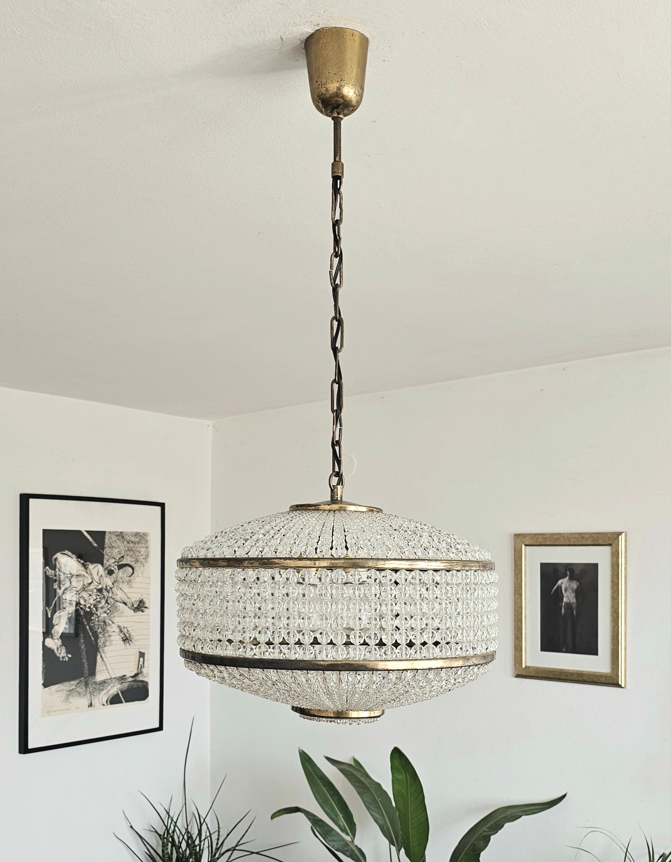In this listing you will find a gorgeous and very rare Mid Century Modern brass chandelier with by J.L Lobmeyr. It features over 2500 Swarovski crystal beads that, when lit on, create beautiful light and an amazing play of shadows and spark.