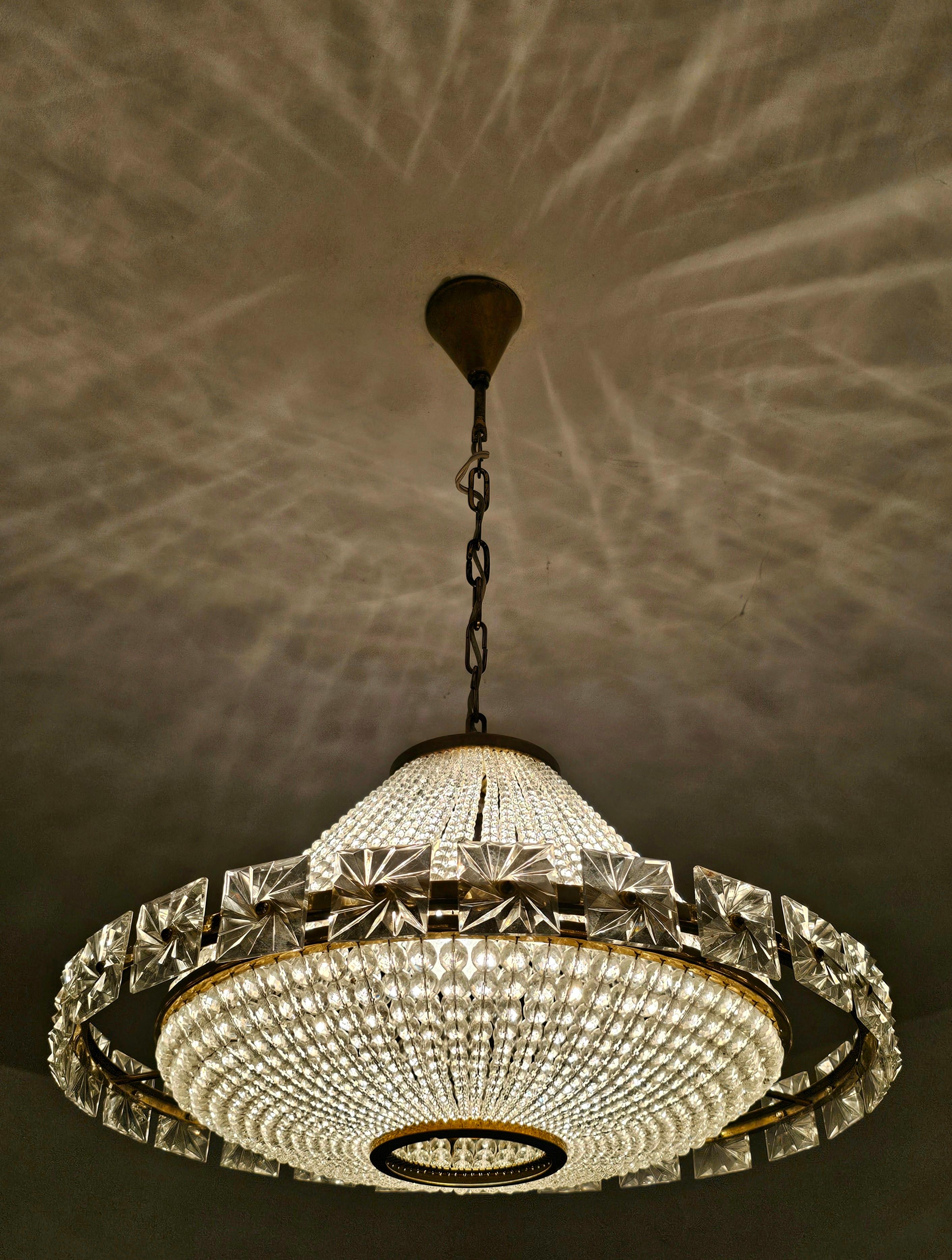 Vous trouverez dans cette annonce un magnifique et très rare lustre OVNI en laiton de style moderne du milieu du siècle, réalisé par I.L.A. Lobmeyr. Elle comporte plus de 2500 perles de cristal Swarovski qui, lorsqu'elles sont allumées, créent une