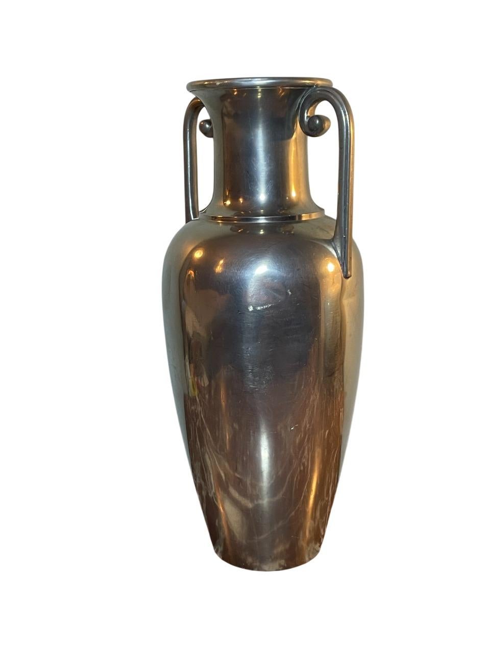 Elegante e senza tempo, questo vaso ad anfora in peltro lucido è stato disegnato da J.L.A.) per l'iconica casa di design svedese Svenskt Tenn negli anni Trenta. Caratterizzato da graziose maniglie a doppia voluta e da un corpo elegante e allungato,