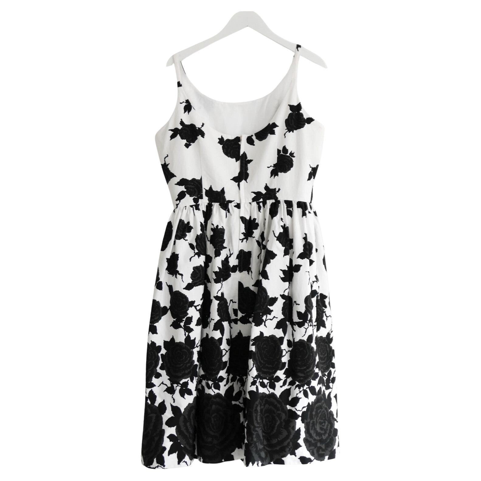 Robe d'été absolument magnifique, super féminine et flatteuse de A&M Davidson. 

Confectionnée en coton blanc impeccable et imprimée de roses graduées noires et grises, elle présente une coupe inspirée du bal de fin d'année des années 1950 avec un