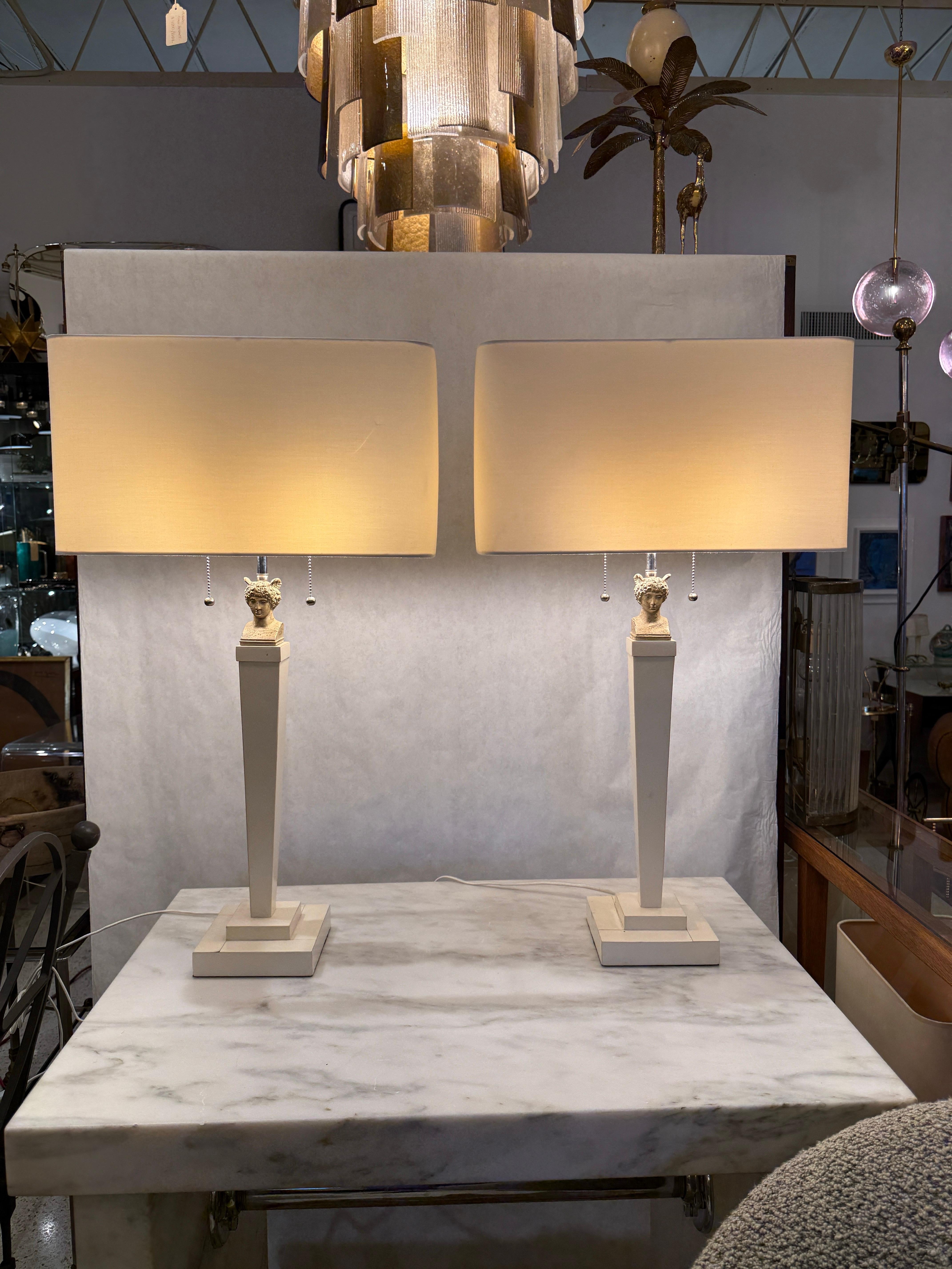 Ces lampes à colonne revêtues de parchemin sont ornées d'un magnifique buste en métal peint d'Hermès, le dieu messager grec.   Ils ont chacun des prises à double faisceau avec des tirettes et un câblage en soie.  Les abat-jour illustrés ne sont pas