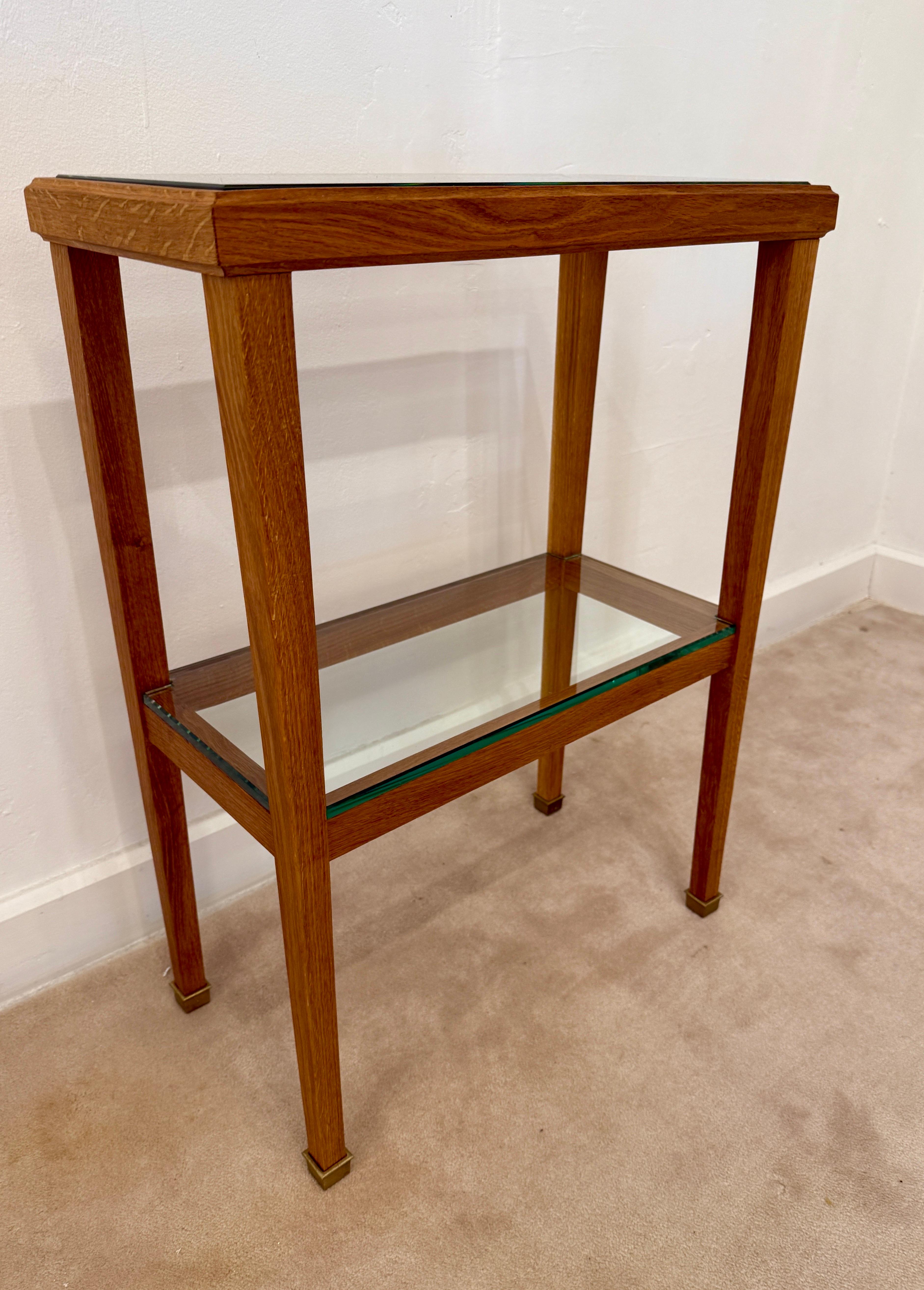 Very rare petite designed oak framed console that is well constructed and lots of attention to detail. Oak is finished with a wax matte tone and gives a rich natural hue. This two=tiered console boasts brass sabots and 1/2 inch thick glass embedded