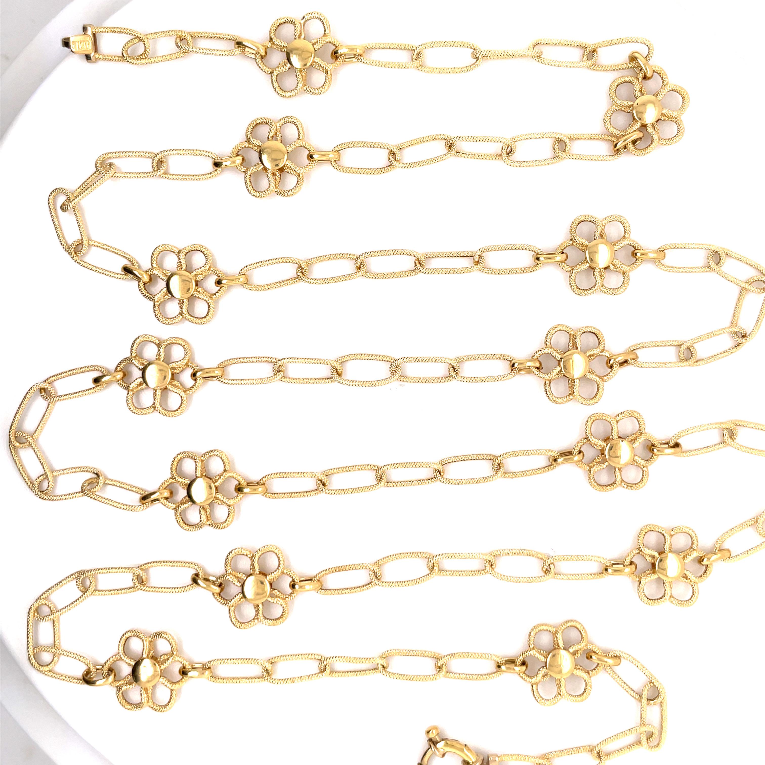 Stamped JMP ITALY 750, this 18 karat yellow gold necklace featuring 13 florals motifs in between oval links weighing 12.9 grams, 35.5 inches. 