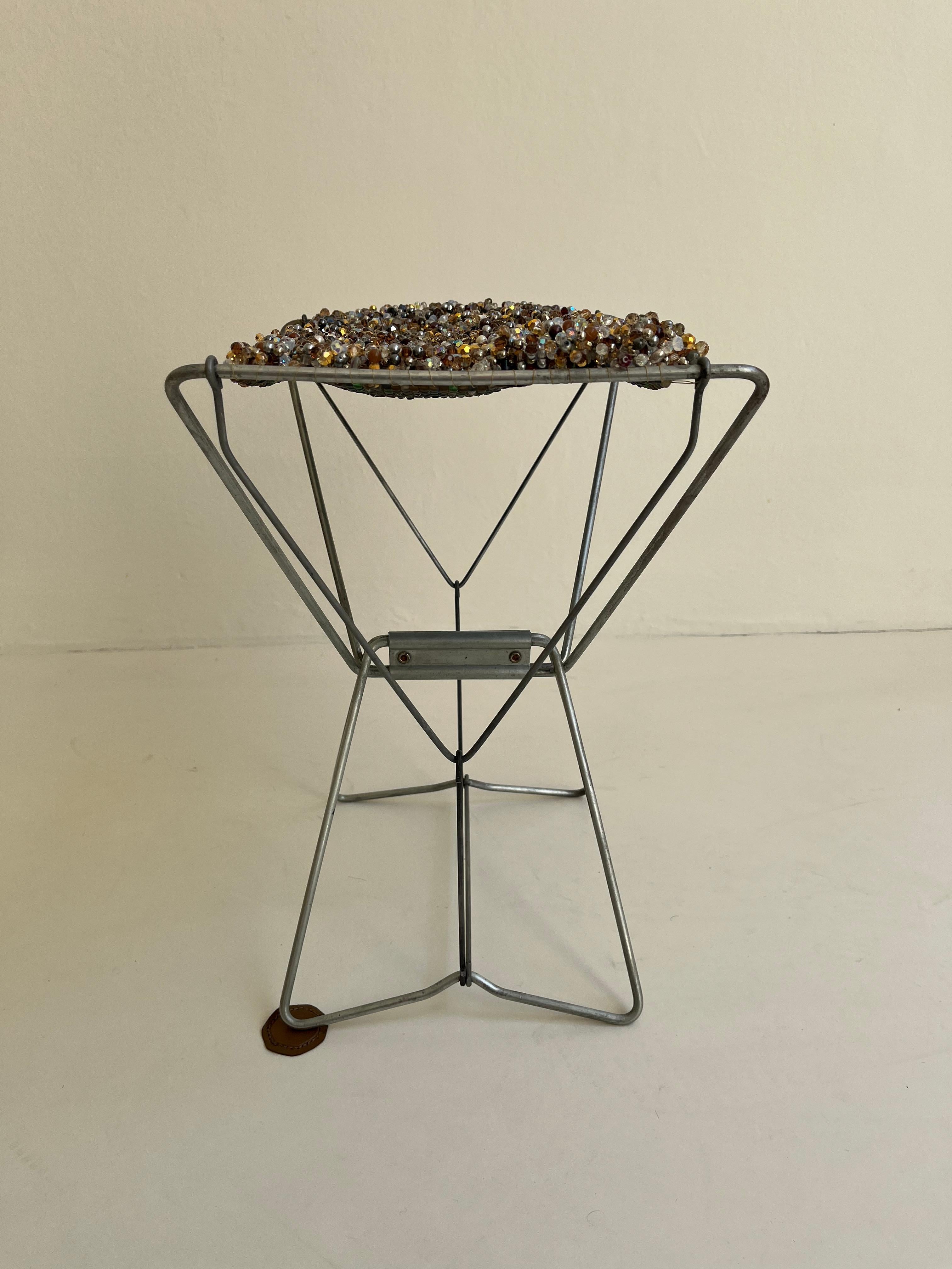 Vintage Fishermen stool in galvanized metal whose seat has been replaced by a weaving of glass beads. The stool becomes an interior Jewel.
(IT IS NOT POSSIBLE TO SIT ON THIS STOOL)

With this set of old-fashioned stools, JN. Mellor Club continues