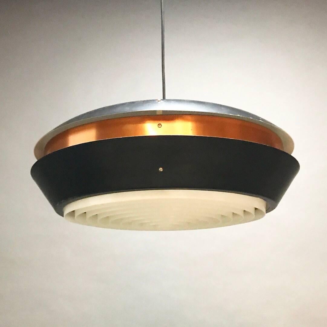 Beautiful Danish midcentury copper ceiling light attributed Fog & Mørup, Denmark, 1960s.

The light is shaped like a UFO saucer of two large parts of black lacquered metal and a centre of copper. 

Ideal as a table light due to the plastic grid