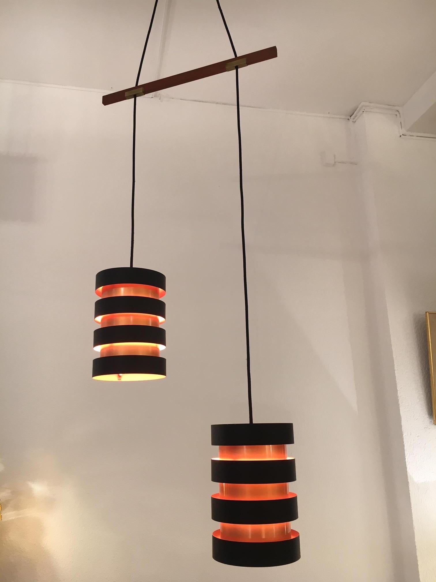Copper and black painted metal double pendant lamp by Jo Hammerborg produced by Fog & Morup, Denmark, circa 1960s.
Separated by a teak stem, height can be adjust, teak canopy at the ceiling.
Each shade: H 25 x D 17.5 cm
Can be sold separate from