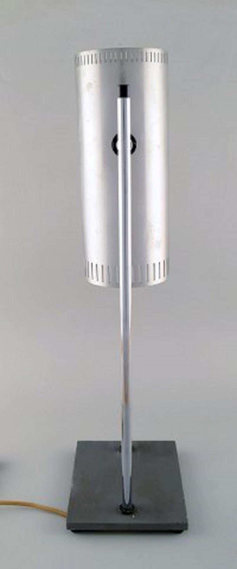 Jo Hammerborg für Fog & Mørup. Posaunentischlampe aus verchromtem und poliertem Stahl mit verstellbarem Schirm, Sockel aus grau lackiertem Metall, 1960er-1970er Jahre.
Maße: 56 x 17,5 cm.
In gutem Zustand mit Gebrauchsspuren.