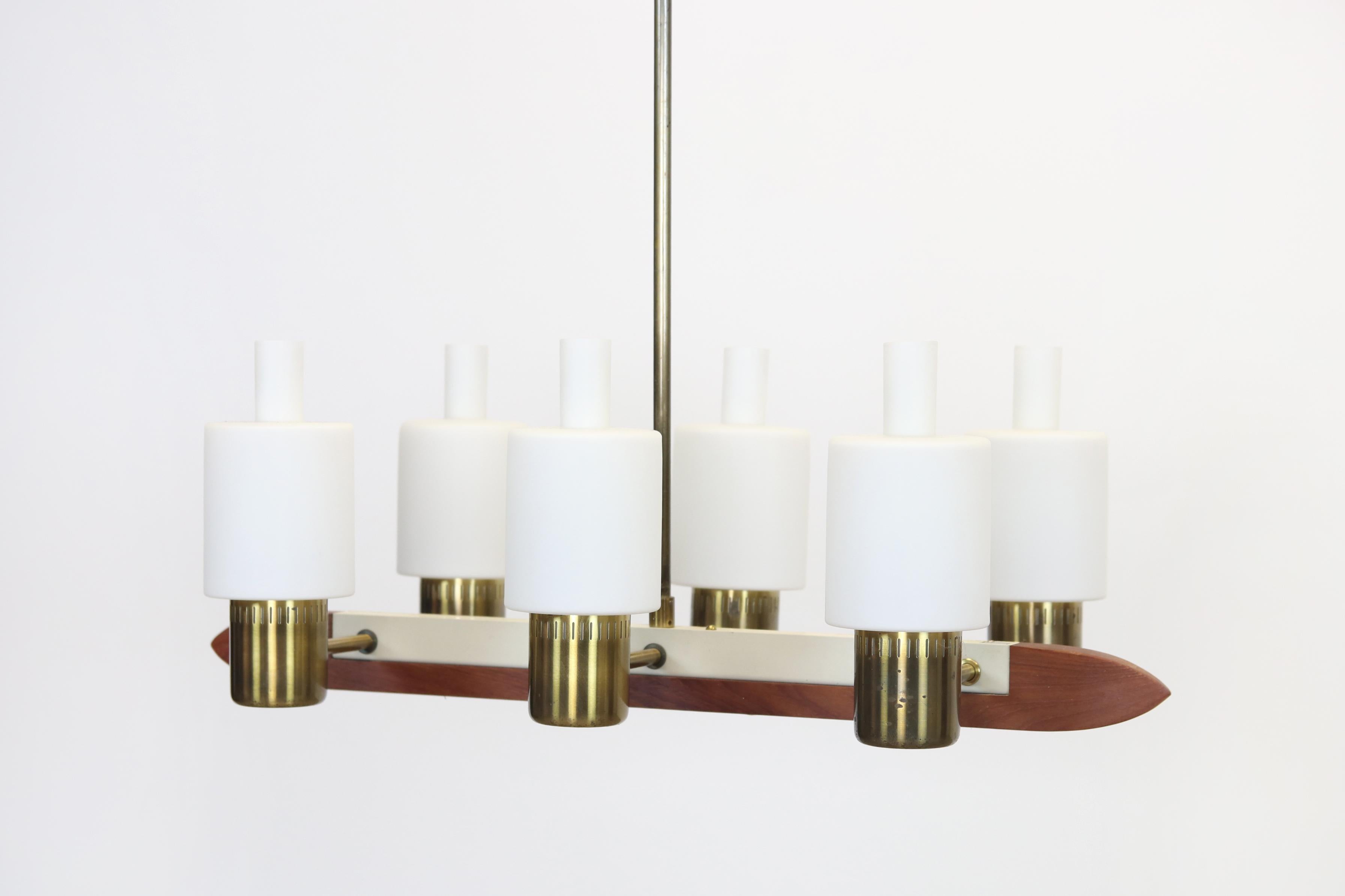 This rare and stylish lamp was designed by the Danish designer Jo Hammerborg for Fog & Mørup in 1962. The Minimalist and elegant design makes clever use of the combination of warm materials such as Teak and Brass in combination with the matte