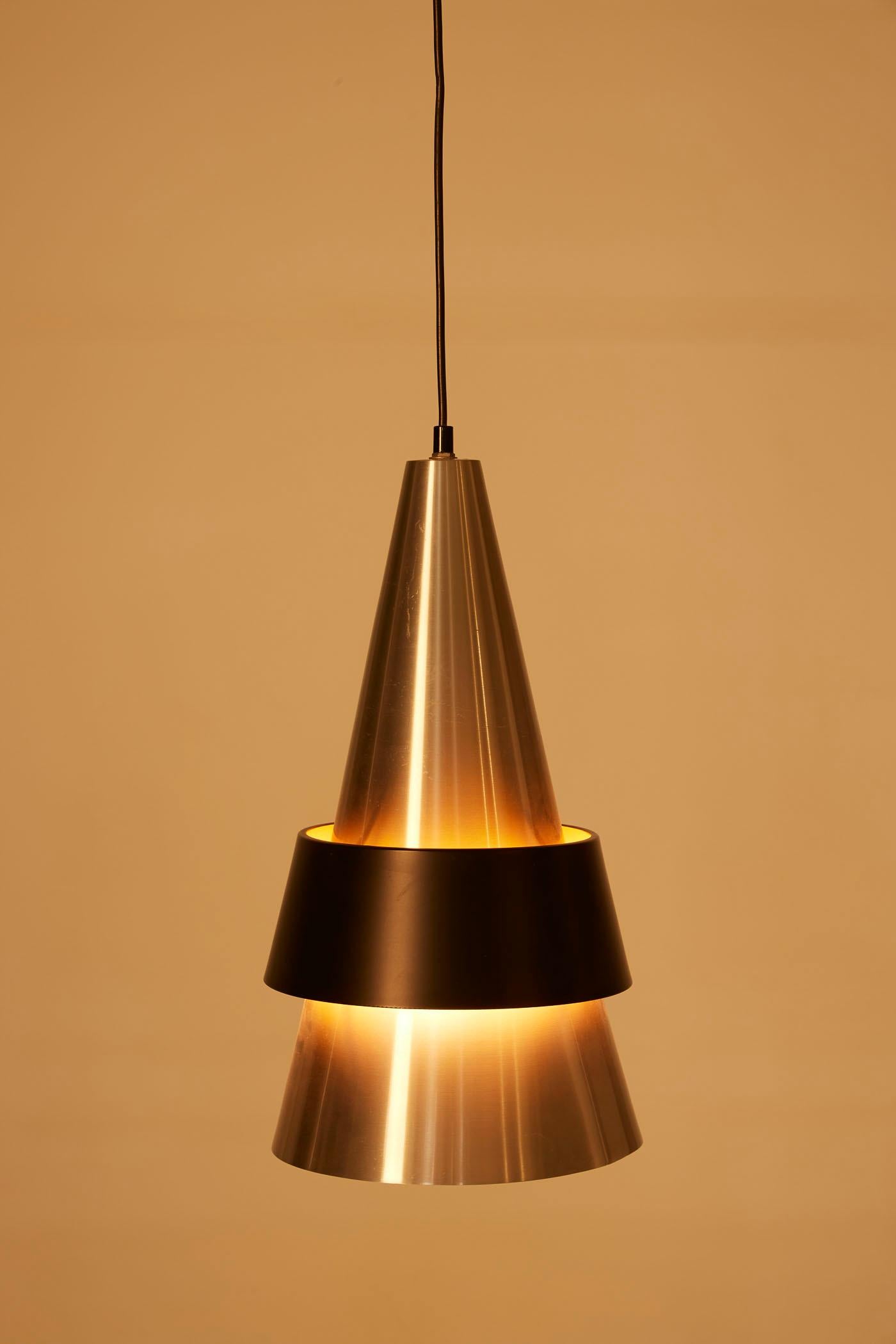 Lampada a sospensione Corona del designer danese Jo Hammerborg per Fog & Mørup, degli anni '60. Il riflettore conico è realizzato in metallo spazzolato con un anello in metallo laccato nero. Ottime condizioni.
DV429-DV430-DV431