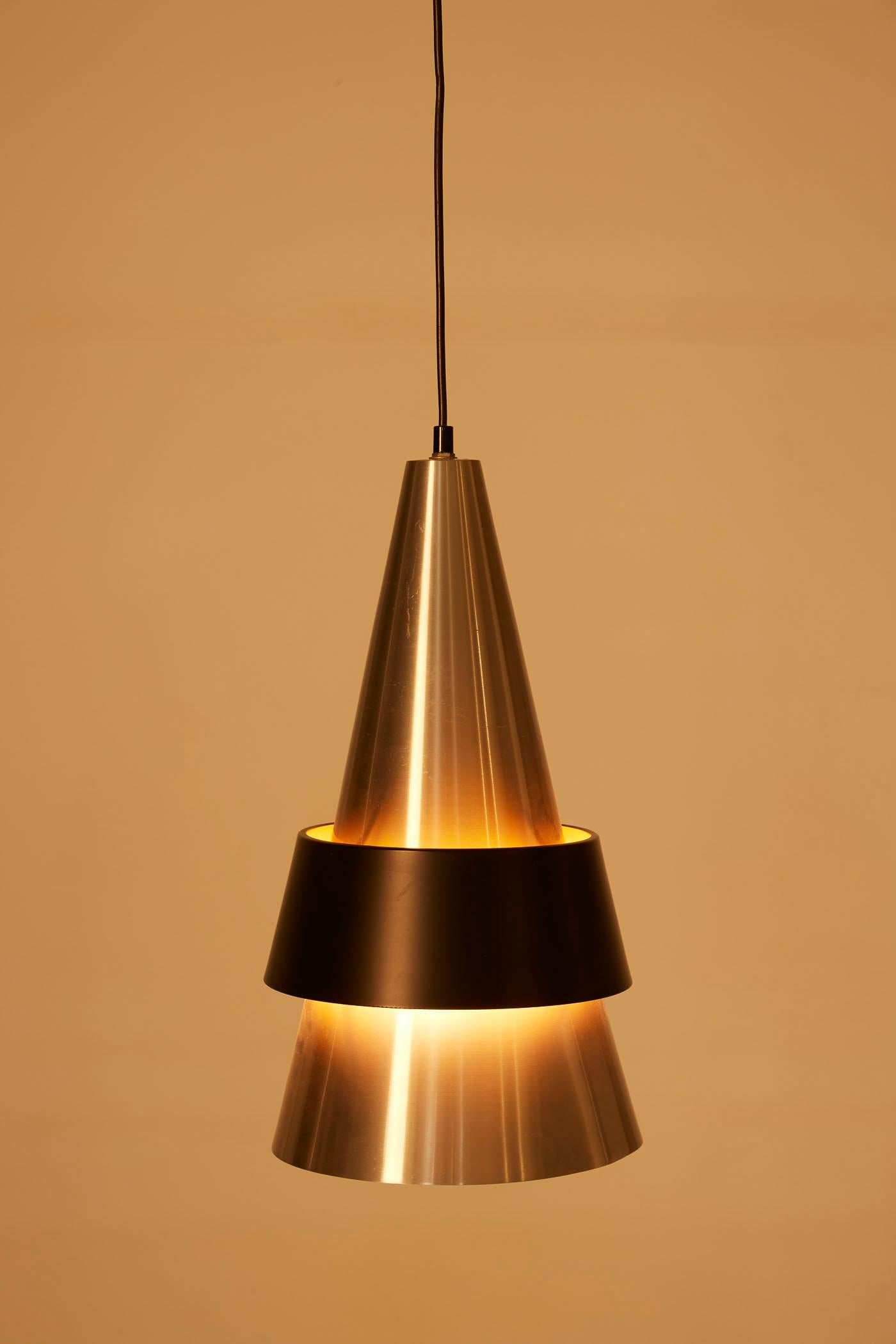 Corona pendant light by Danish designer Jo Hammerborg for Fog & Mørup, from the 1960s. The conical reflector is made of brushed metal with a black lacquered metal ring. Very good condition.
DV429