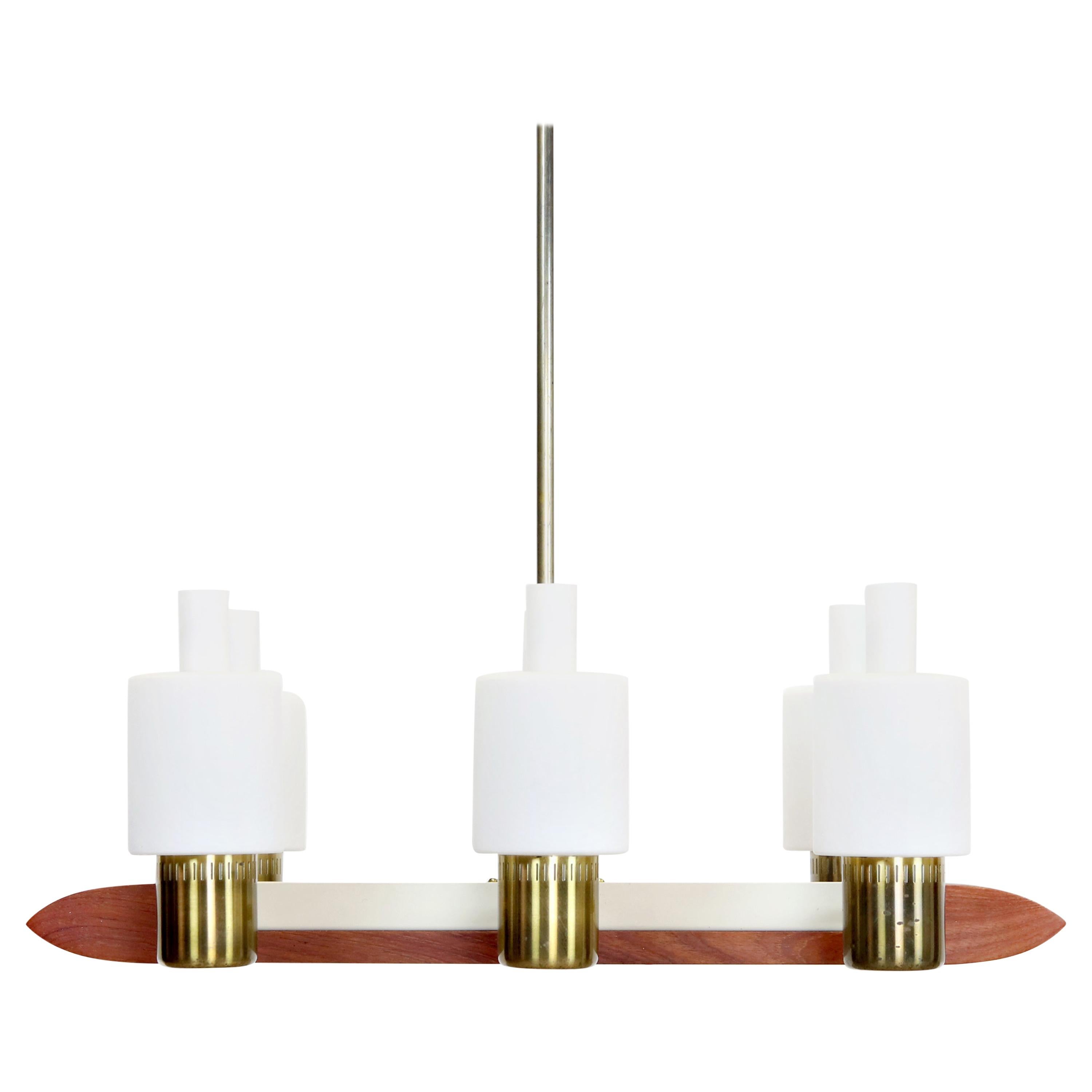 This rare and stylish lamp was designed by the Danish designer Jo Hammerborg for Fog & Mørup in 1962. The Minimalist and elegant design makes clever use of the combination of warm materials such as Teak and Brass in combination with the matte