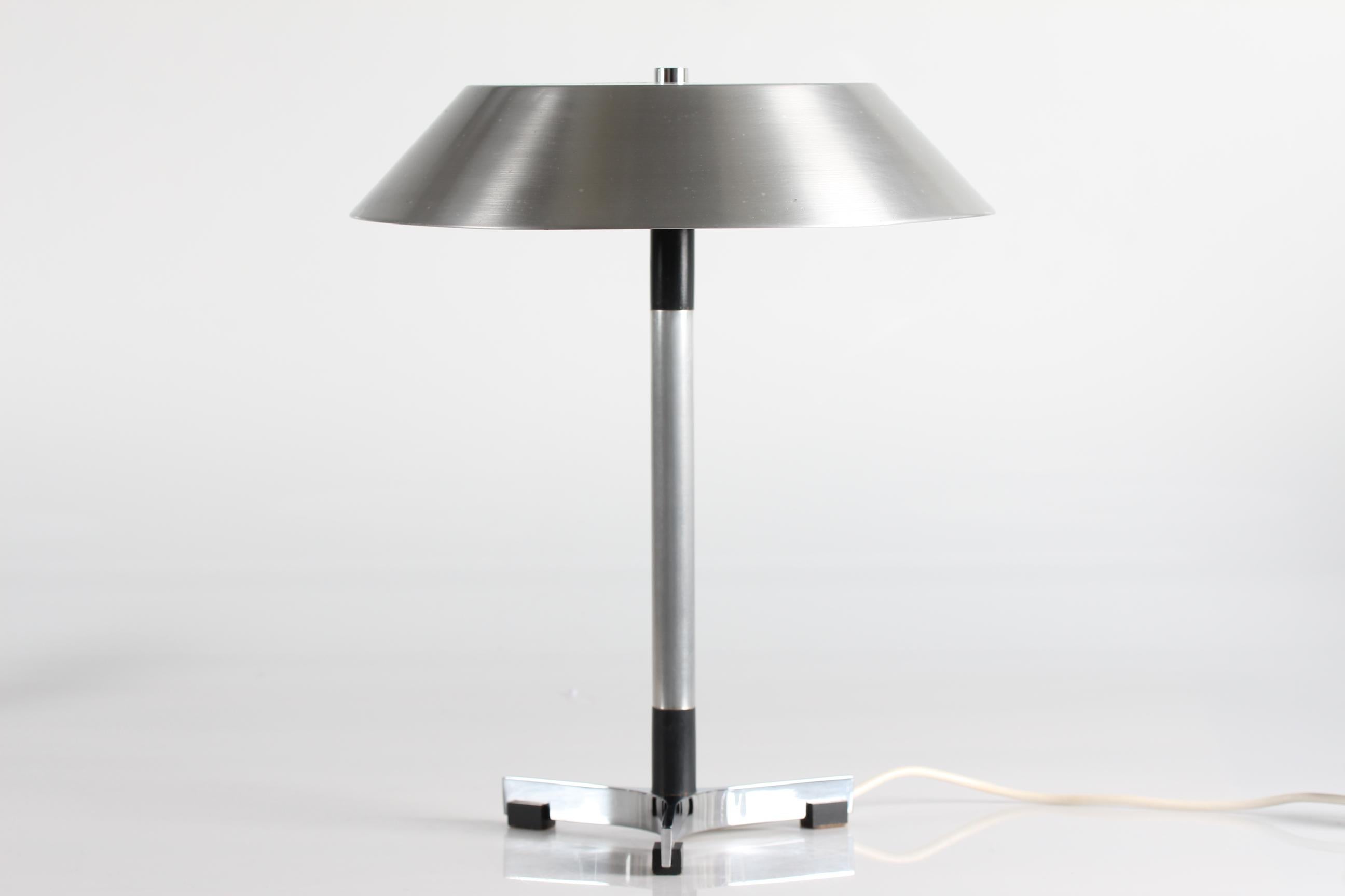 Danish vintage table- and desk lamp model President designed by Jo Hammerborg in the 1960s.
This one is made of aluminium with brushed steel look outside.
At the inside of the shade is white lacquered. The stem and foot have small parts of black