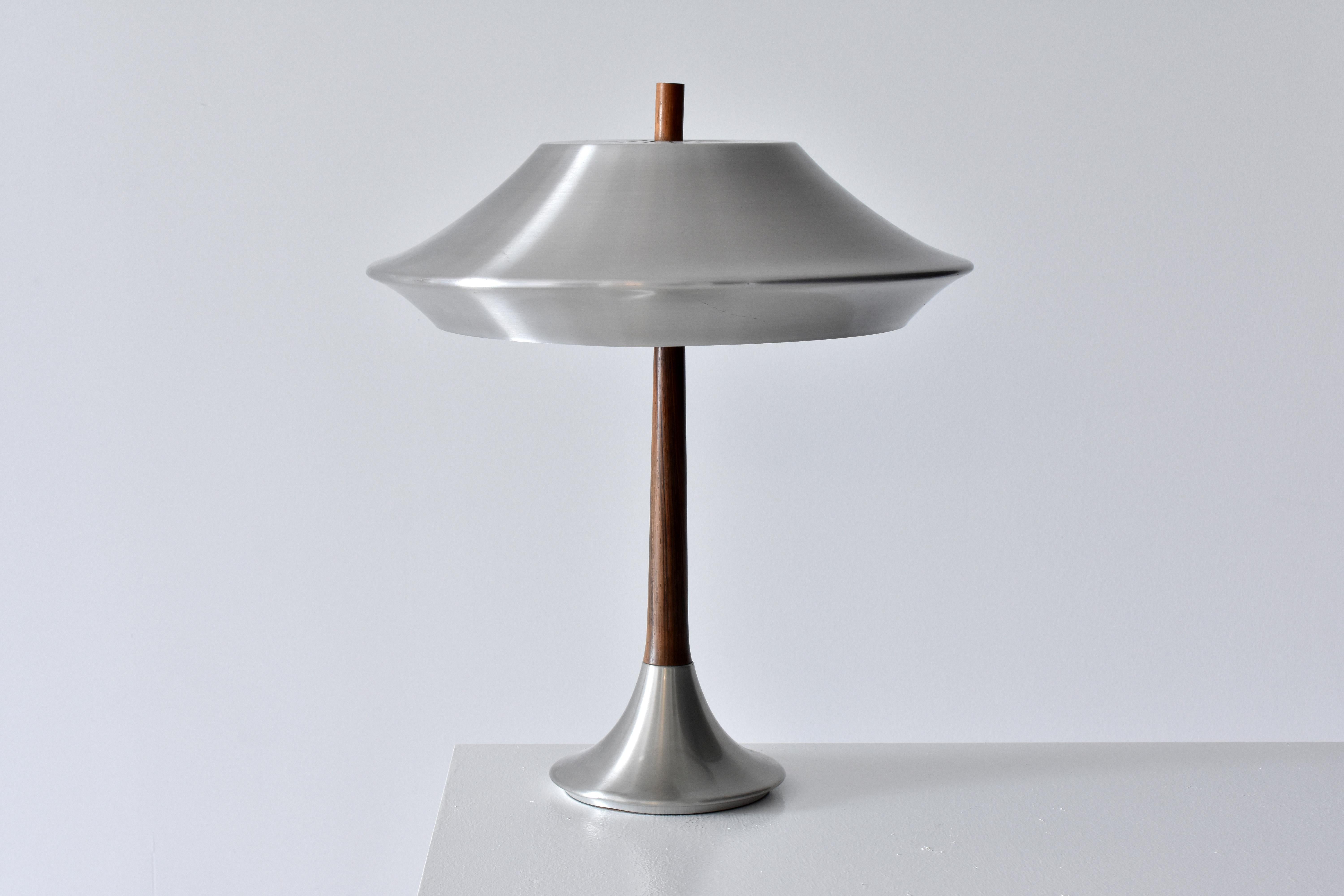A table lamp designed by Jo Hammerborg. Produced by Fog & Mørup in the 1960's. Executed in Aluminium and Rosewood. 

Jo Hammerborg, trained at the Royal Danish Academy of Fine Arts, served as design head at Fog & Mørup. Prior, Hammerborg worked as a