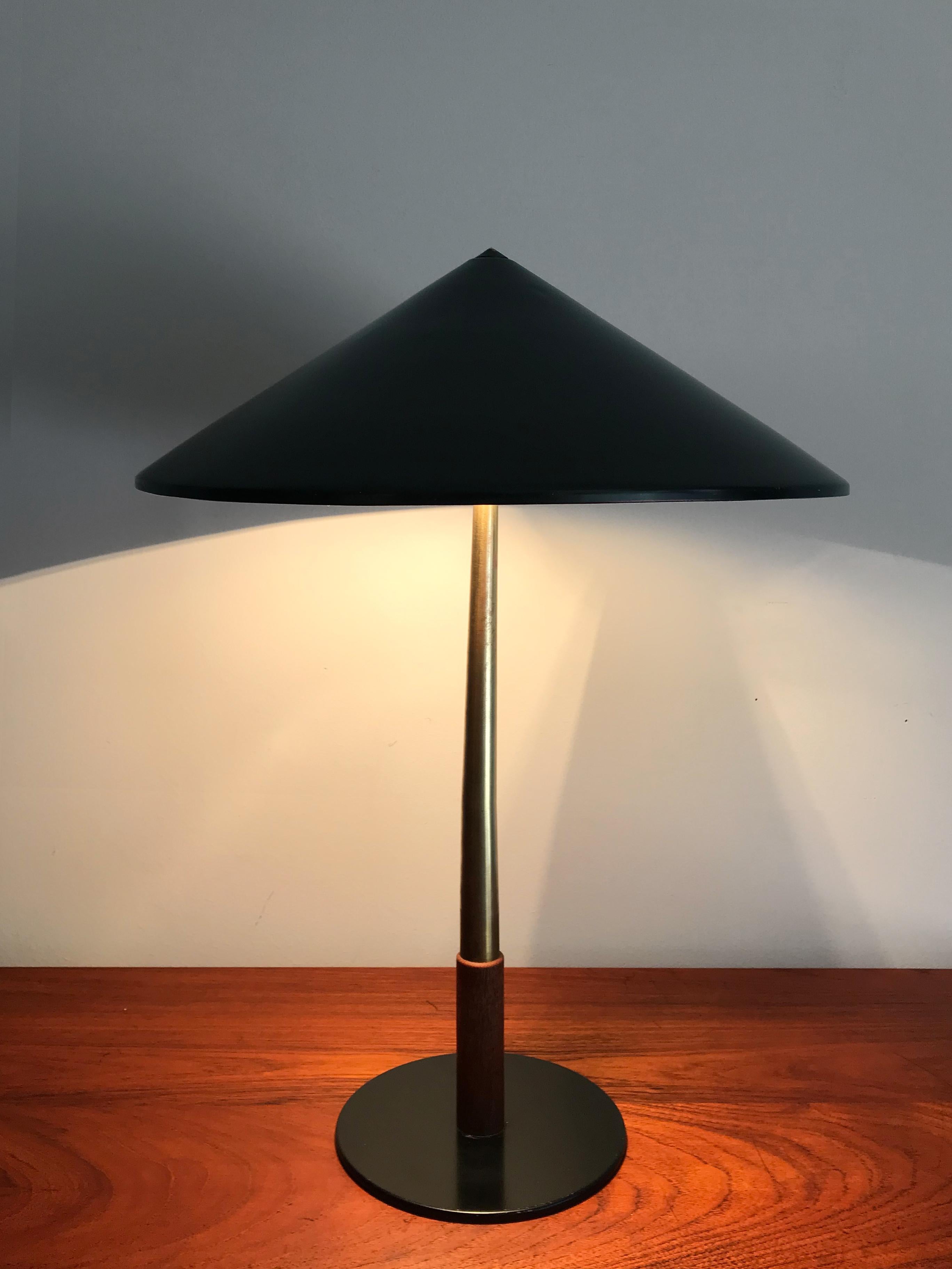 Very rare Danish desk or table lamp designed by Jo Hammerborg for Fog & Morup, brass stem and teak detail, painted metal hat, original manufacturing label, early 1950s.

Please note that the lamp is original of the period and this shows normal