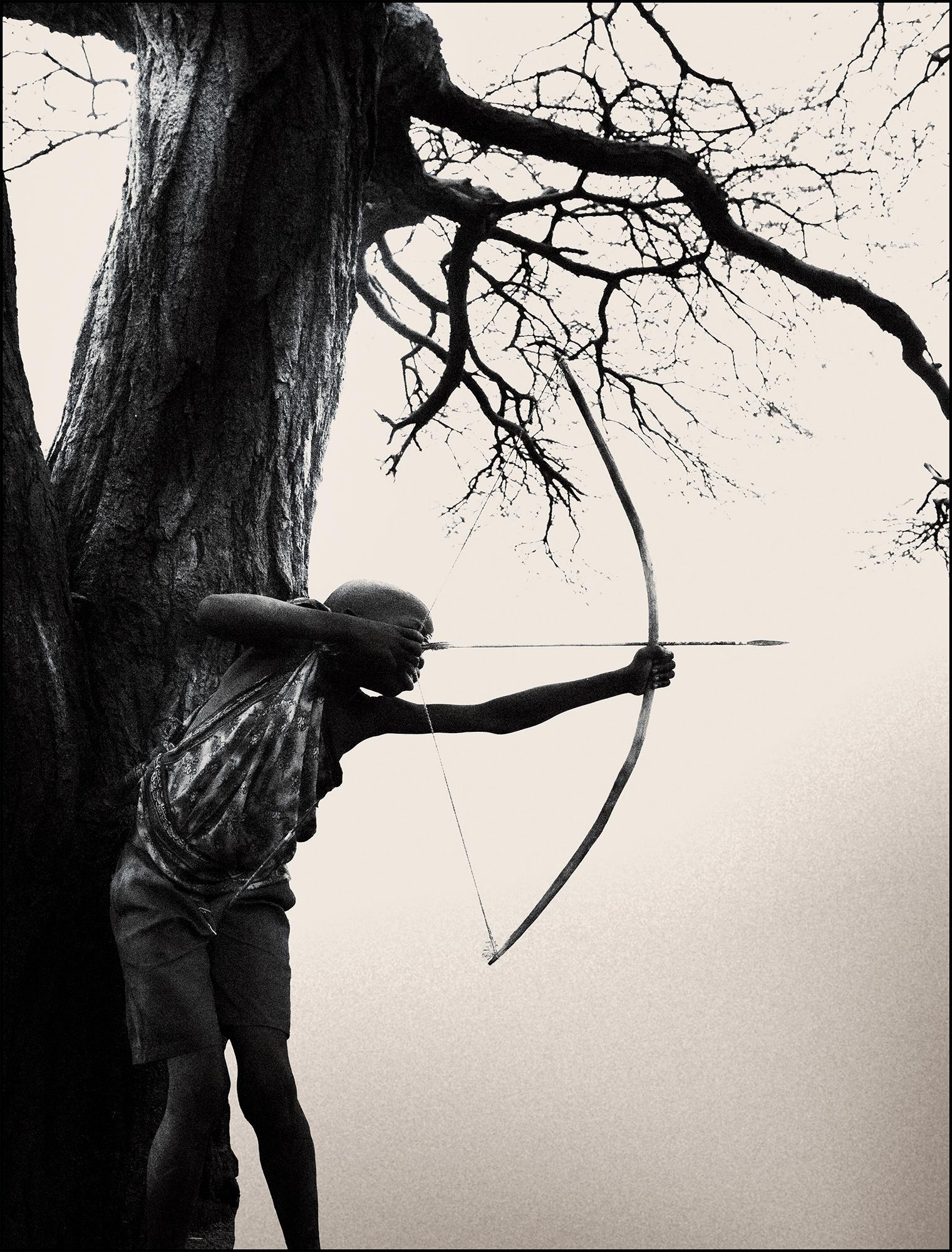 Hadza Arrow, people, africa, black and white photography, boy, bow and arrow - Photograph by Joachim Schmeisser