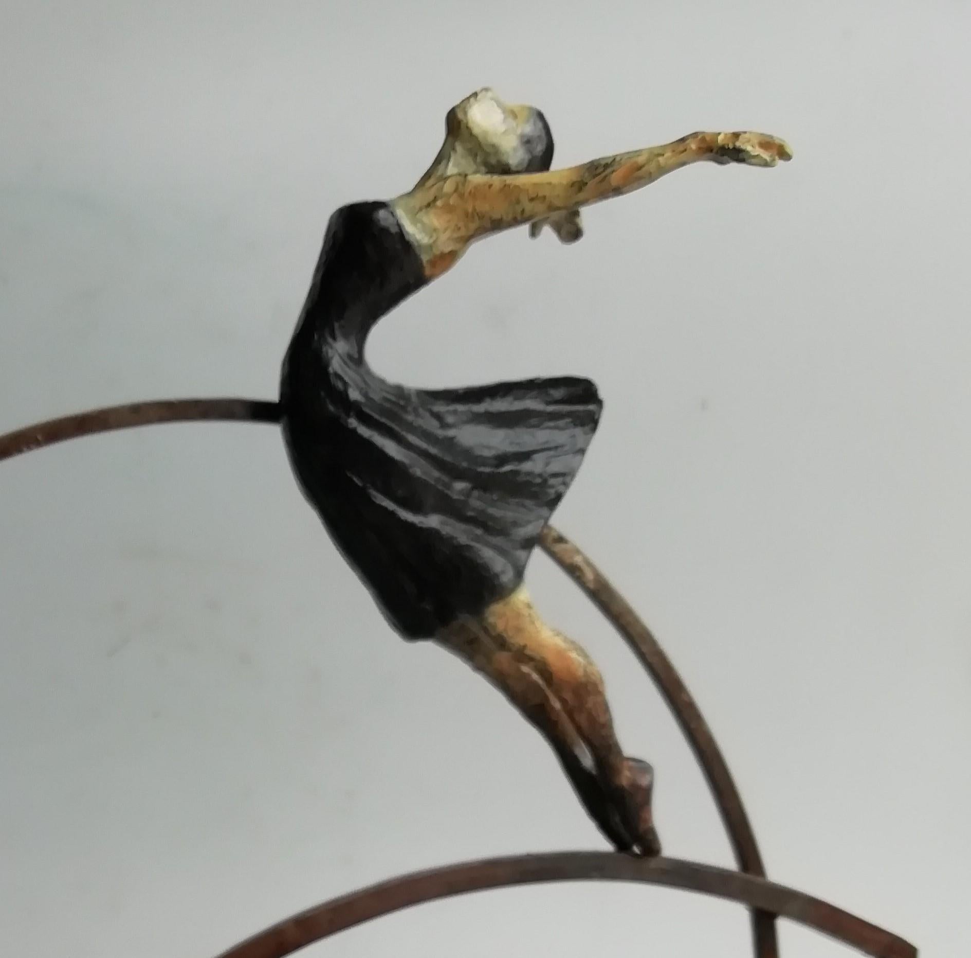 Victory is a bronze sculpture with black and beige patinas, it is connected to a steel base. The edition size is 50. Victory is a depiction of freedom and sense of free will, especially for a woman. This sculpture stands on shelf as well as be hung