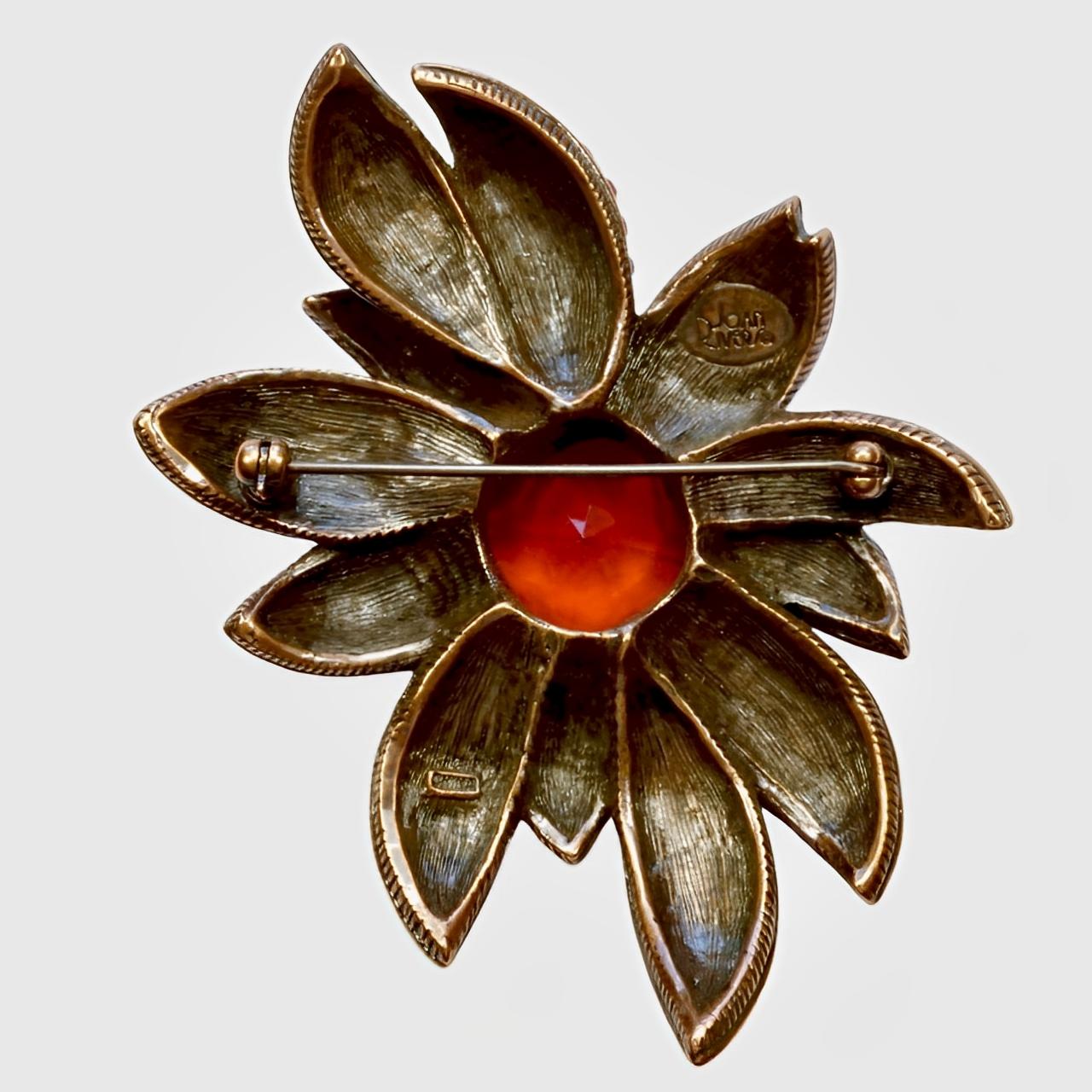 Broche Joan Rivers en forme de grande fleur, ornée de cristaux rouge vif et d'une pierre centrale en verre ambré.

Longueur 7,4 cm / 2,9 pouces et largeur maximale 5 cm / 1,9 pouces.

Il s'agit d'une magnifique et étincelante broche vintage de Joan