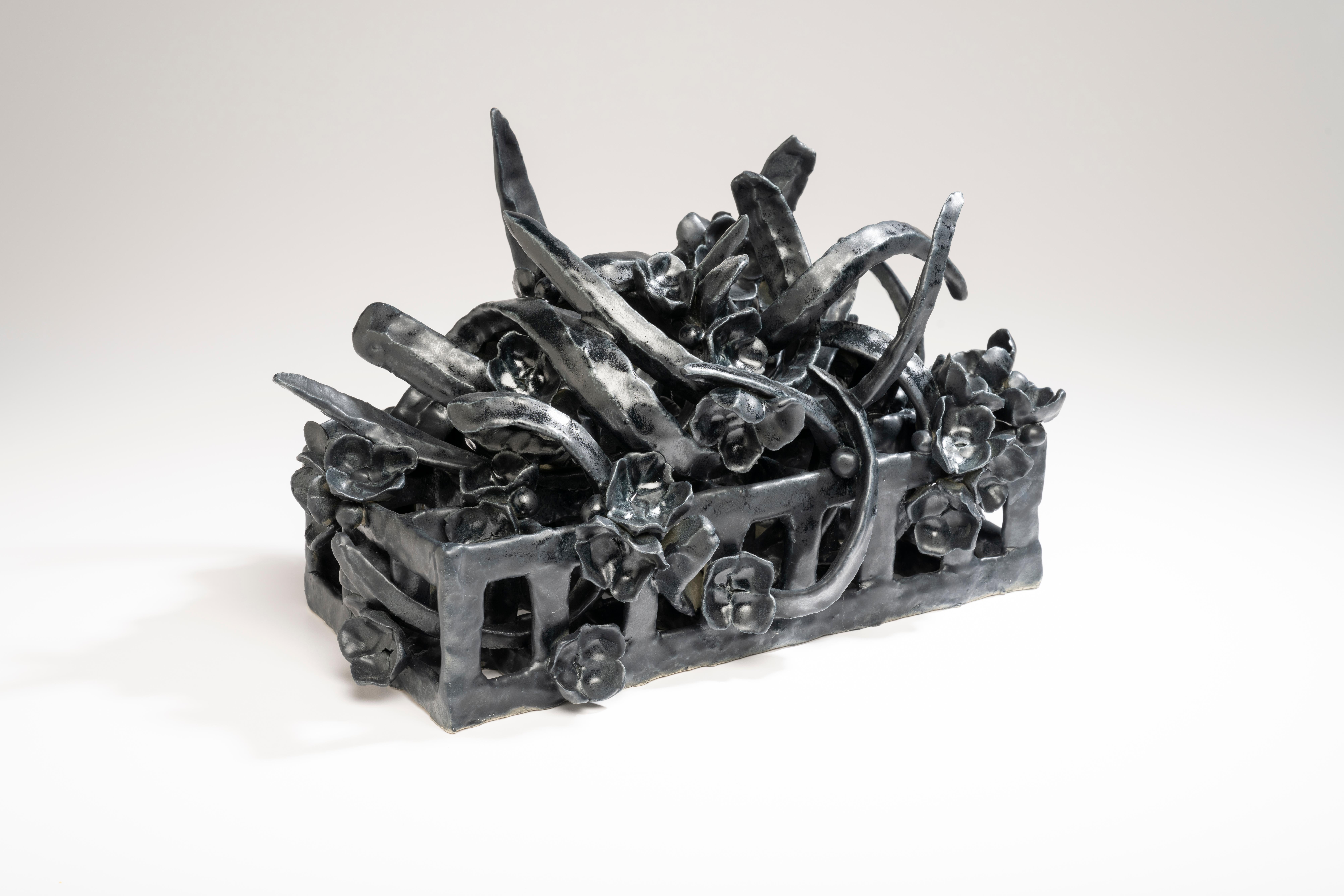 Zeitgenössische amerikanische Keramikkünstlerin Joanna Poag's Binding Time  (Black Grid with leaves) ist Teil einer Serie von Tischskulpturen. Es ist handgefertigter Ton, hoch gebrannt bis Kegel 6 mit Glasur. Binding Time erforscht die Entropie im