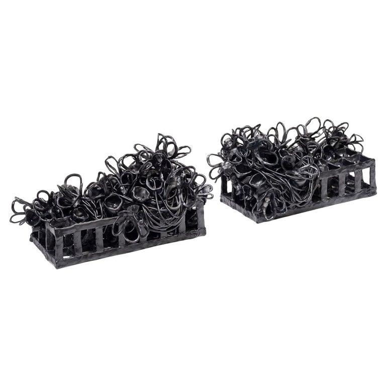 Contemporary American ceramic artist Joanna Poag's pair of Binding Time (Black Grid with Flowers and Pods) tabletop sculpture is part of a series. They are hand built clay, glaze fired to cone 6 with cobalt wash. Binding Time explores entropy as it