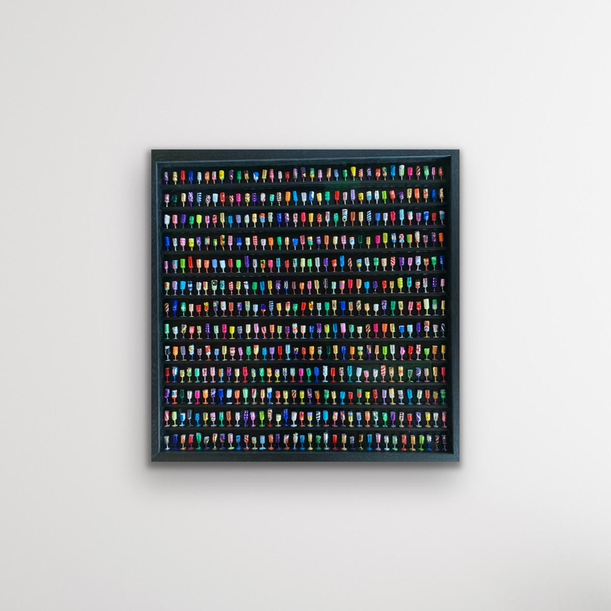 Goblets IX is a signed original wall sculpture made from sweet wrappers by Joanne Tinker of a selection of colourful wine goblets on a black shelved frame.

Additional information:
Goblets XXIV by Joanne Tinker [2022]
Sweet Wrappers
Image size: H:64