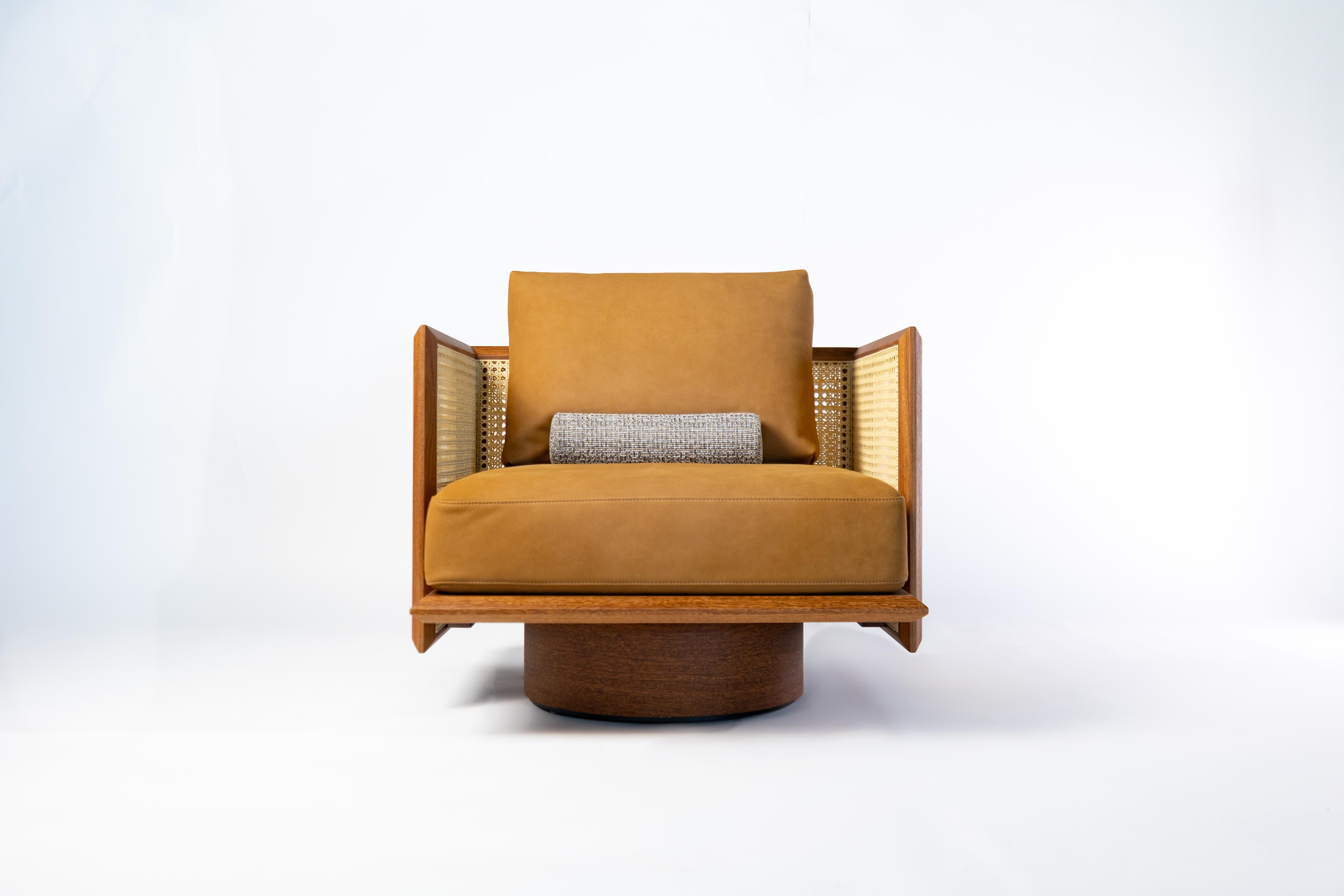 Cet élégant fauteuil de Bruno de Carvalho présente un équilibre raffiné entre l'artisanat, le confort et l'intégrité des matériaux. Sa structure est méticuleusement fabriquée en bois massif, avec des bords biseautés et une menuiserie traditionnelle