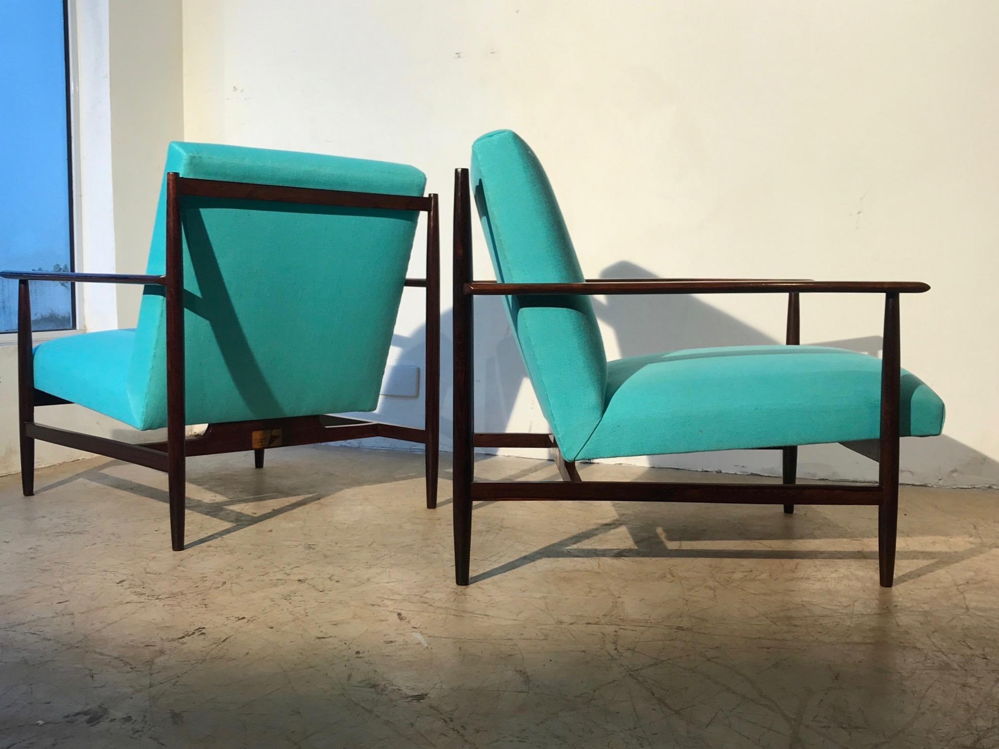 Joaquin Tenreiro attributed. Pair of Brazilian modern armchair made of solid rosewood with blue upholstery covering. This chairs structures features an extremely sophisticated wooden finishing with amazing rosewood patterns.

Currently only