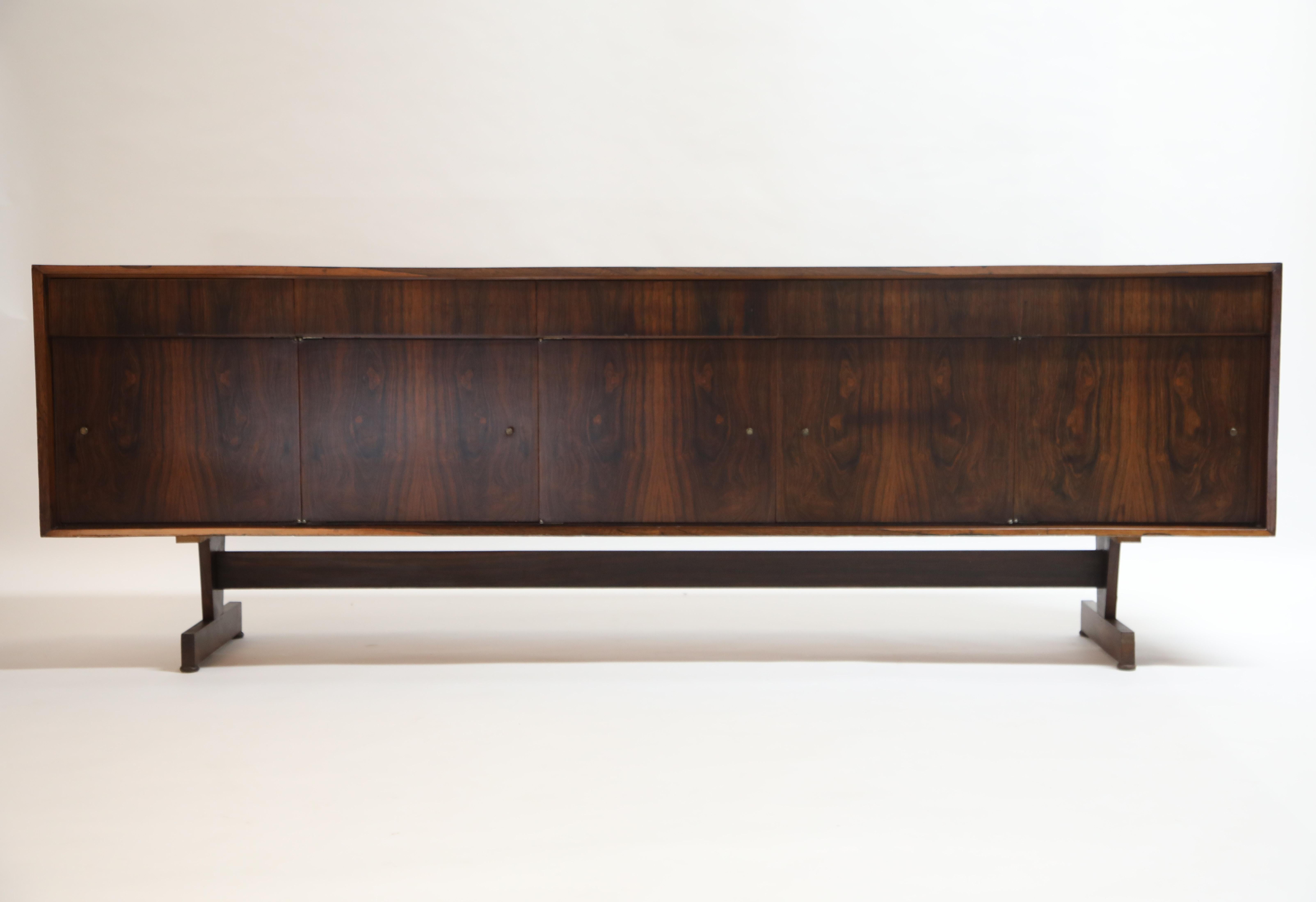 This incredible Joaquim Tenreiro sideboard possesses an incredibly vivid detail to the book-matched Brazilian Jacaranda rosewood grain. Designed and crafted in the mid to late 1950s, this piece still retains its original maker labels on the rear